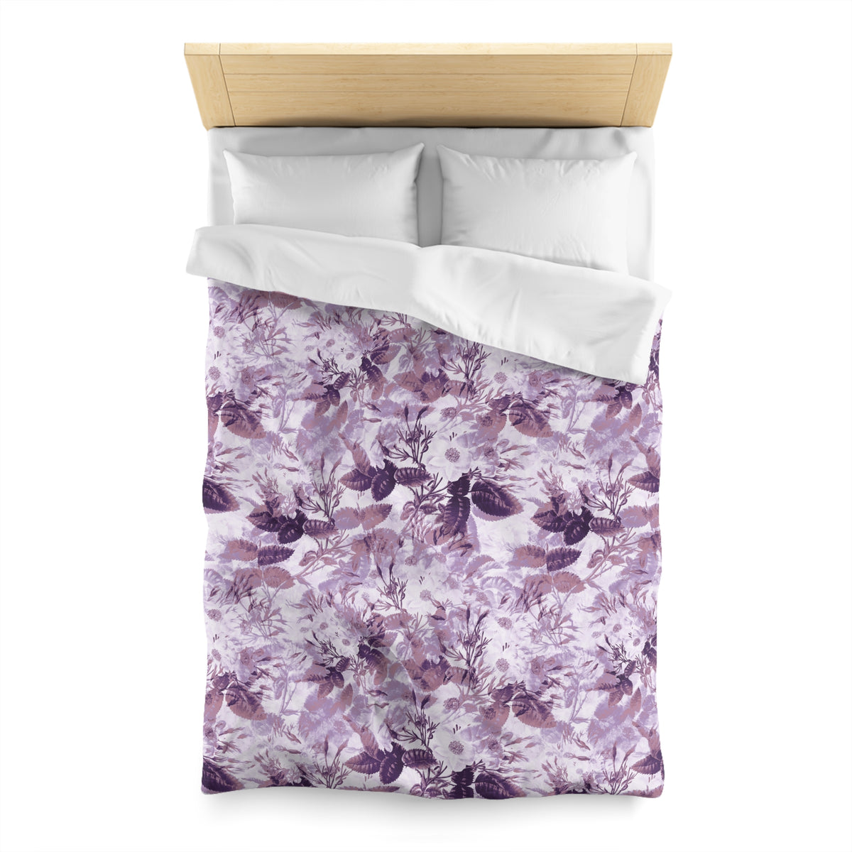 a bed with a floral patterned comforter and pillows.