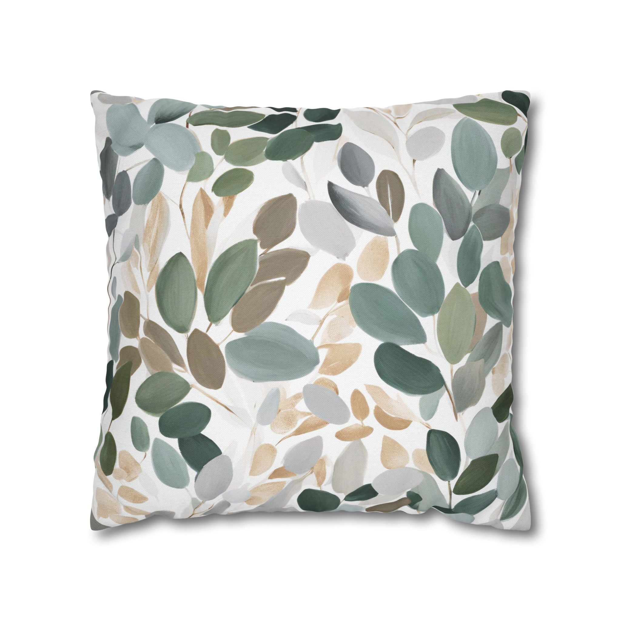 a square pillow with a leafy pattern in various shades of green, brown, and gray.
