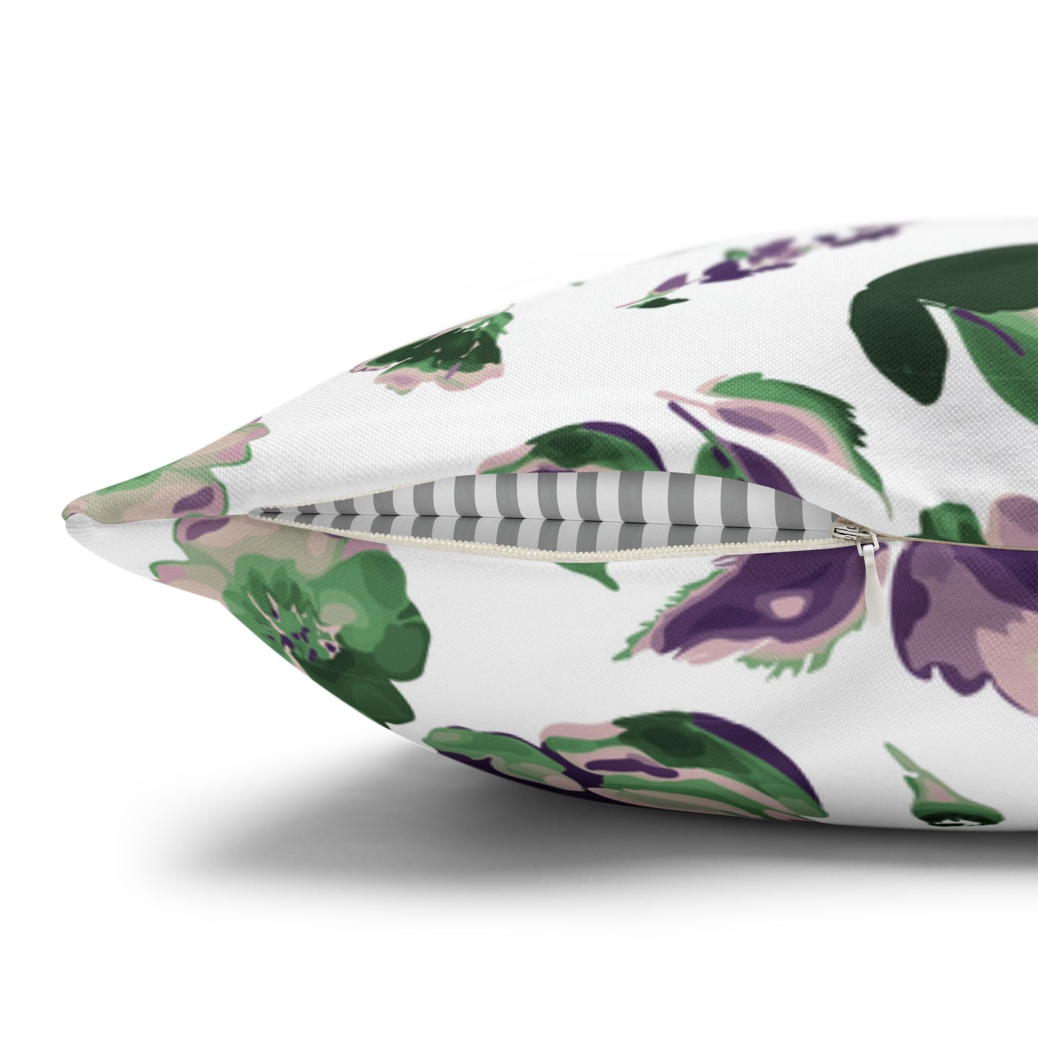 a close-up view of a white pillow with a floral pattern in shades of green and purple.