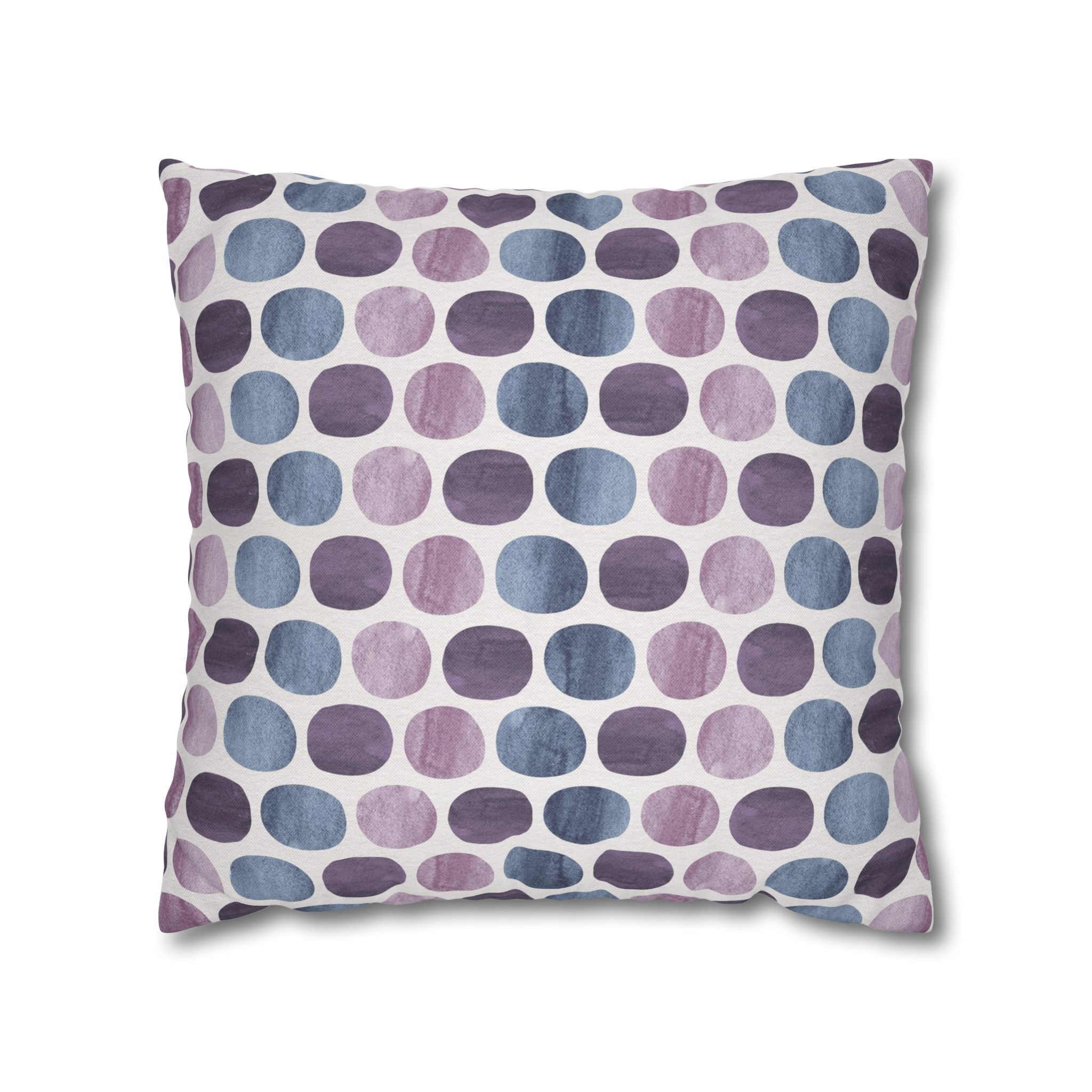 a square throw pillow with a repeating pattern of purple and blue dots on a white background.