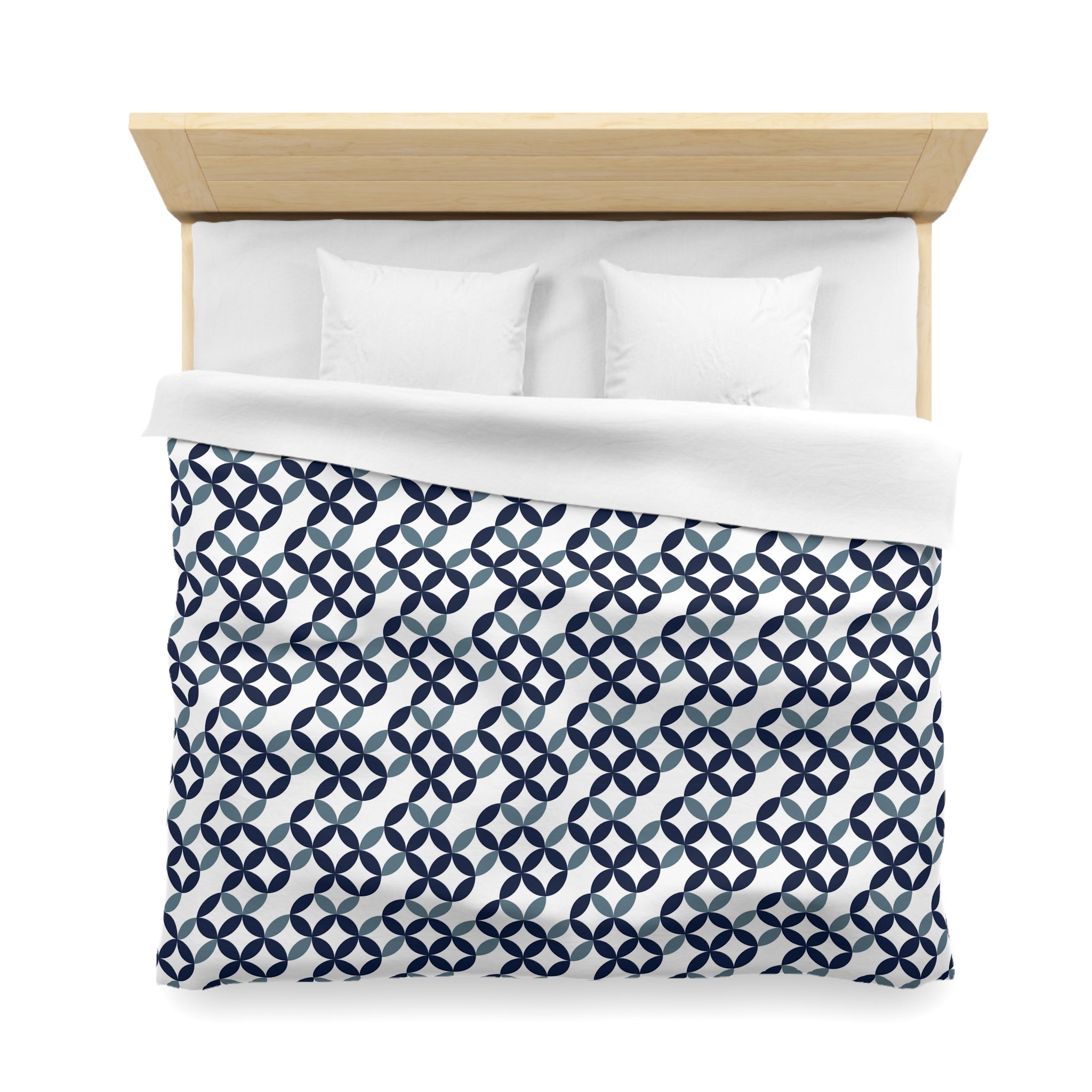 a neatly made bed with a blue and white patterned comforter and two white pillows.
