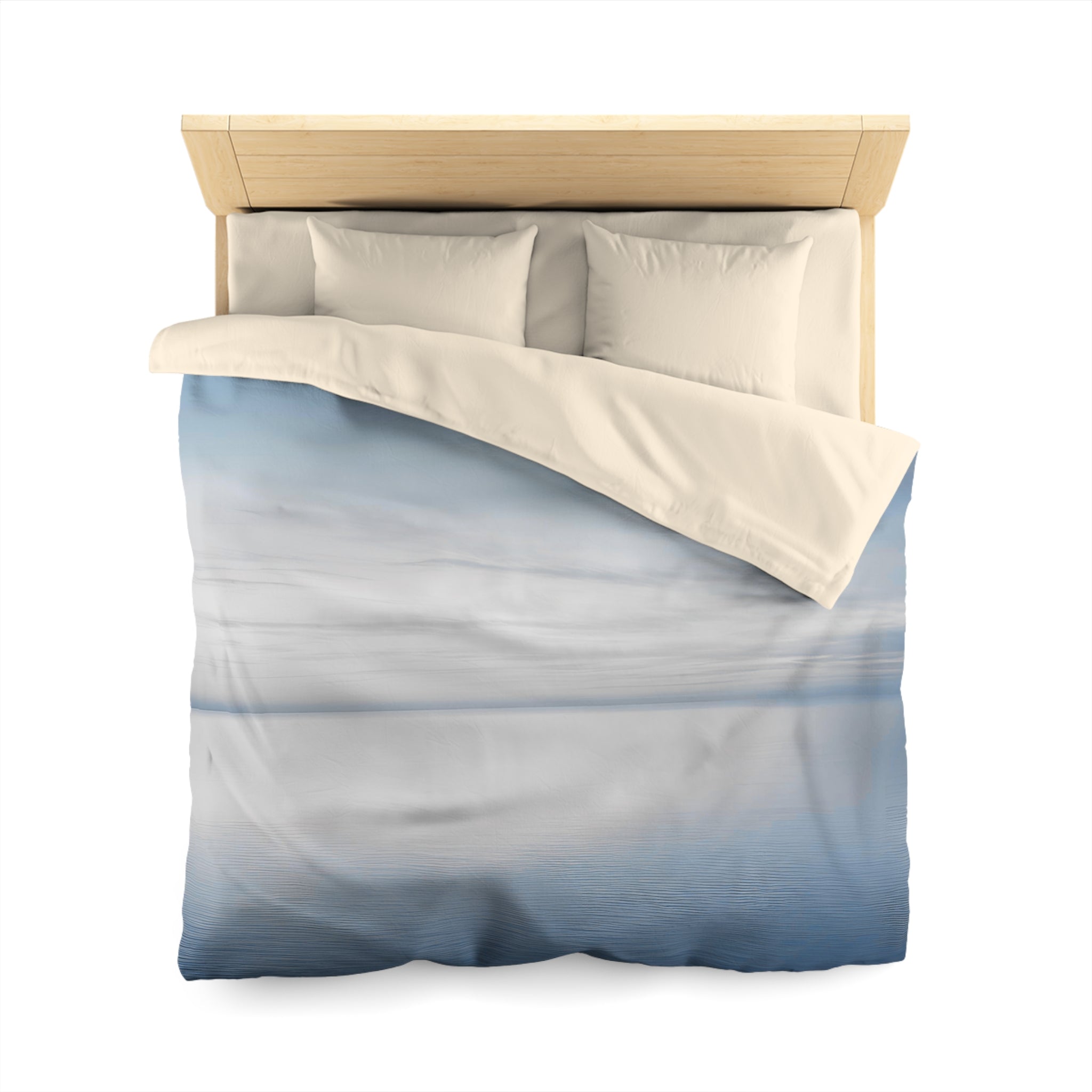 A bed with a blue and white patterned comforter and pillows, set against a white background.