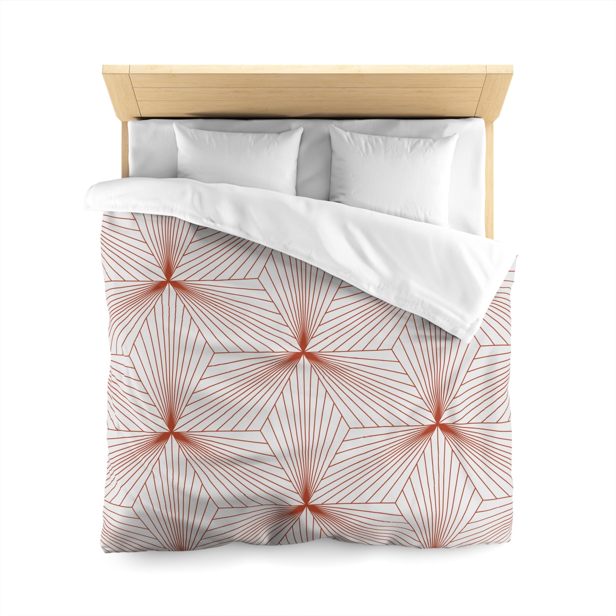 a bed with a white comforter and a red and white geometric pattern on it.