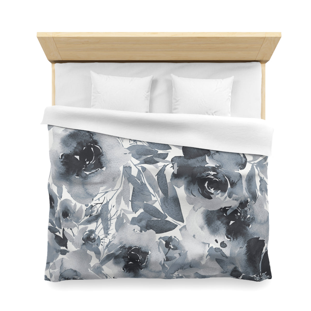 a neatly made bed with a floral print duvet cover and two white pillows.