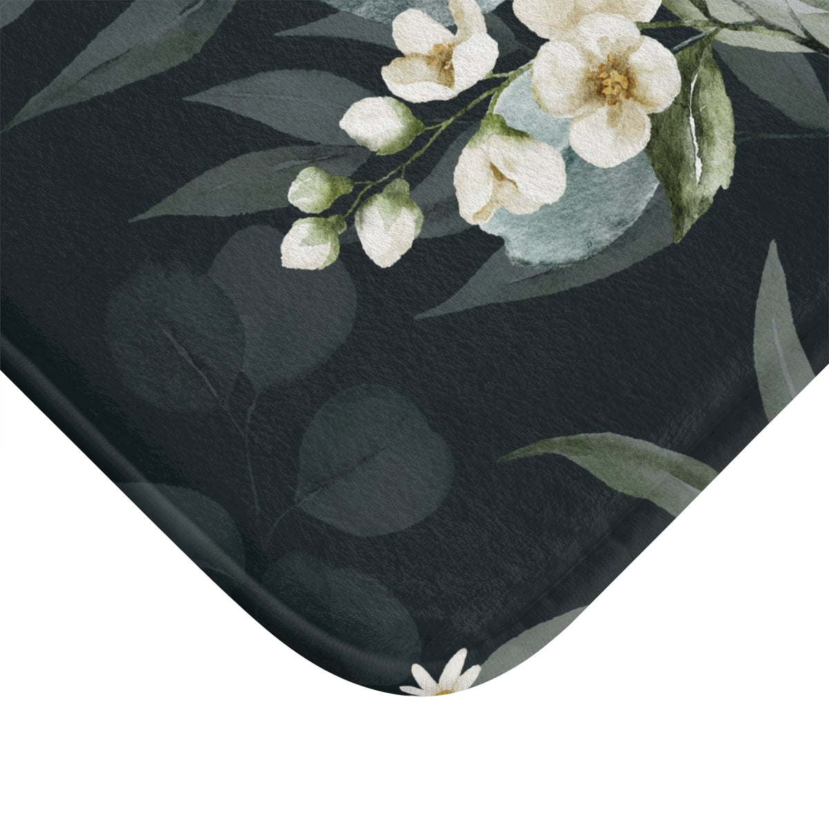 a close-up view of a black and white floral pattern on a surface, with white flowers and green leaves.