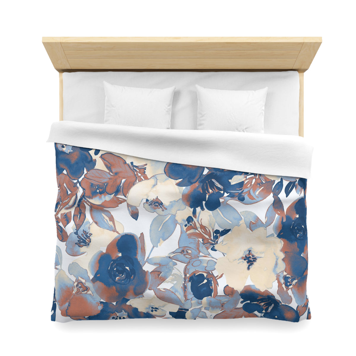 a bed with a floral print duvet cover and white pillows.