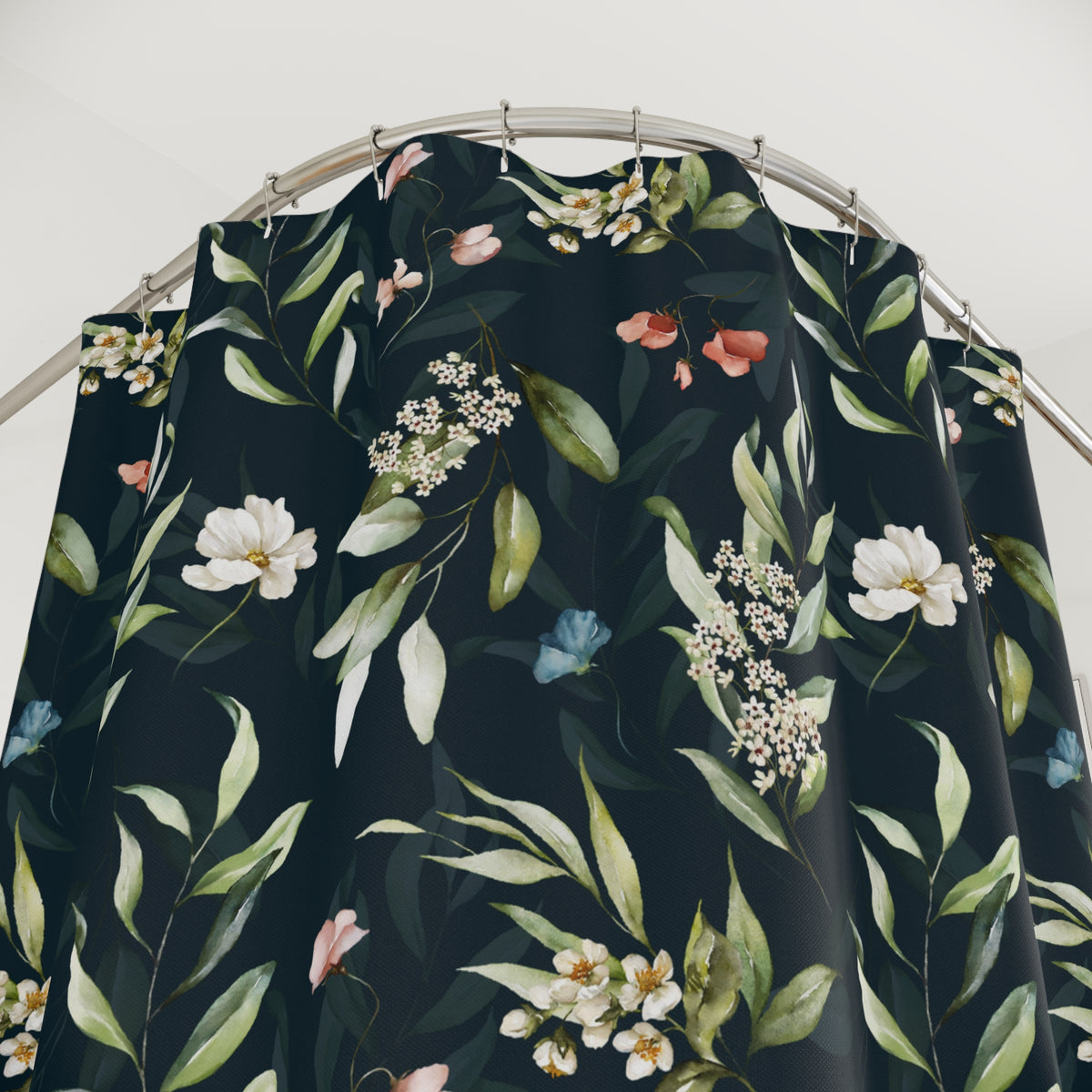 a black shower curtain with a floral pattern of white and pink flowers, green leaves, and blue flowers.
