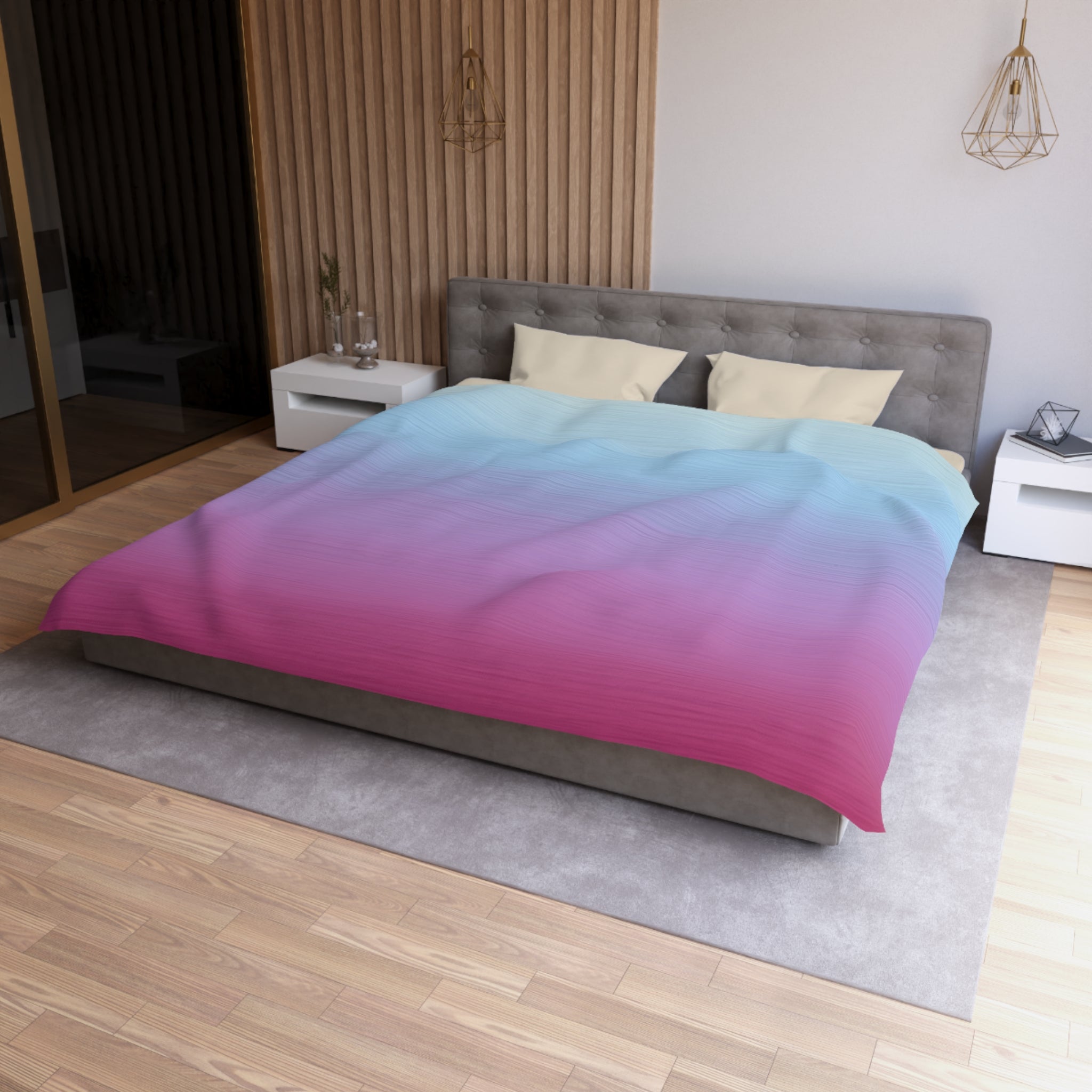 a modern bedroom with a large bed, a gray headboard, and a colorful duvet cover featuring a gradient of pink and blue colors. The room has a wooden floor and white nightstands, and there is a pendant light hanging above the bed.