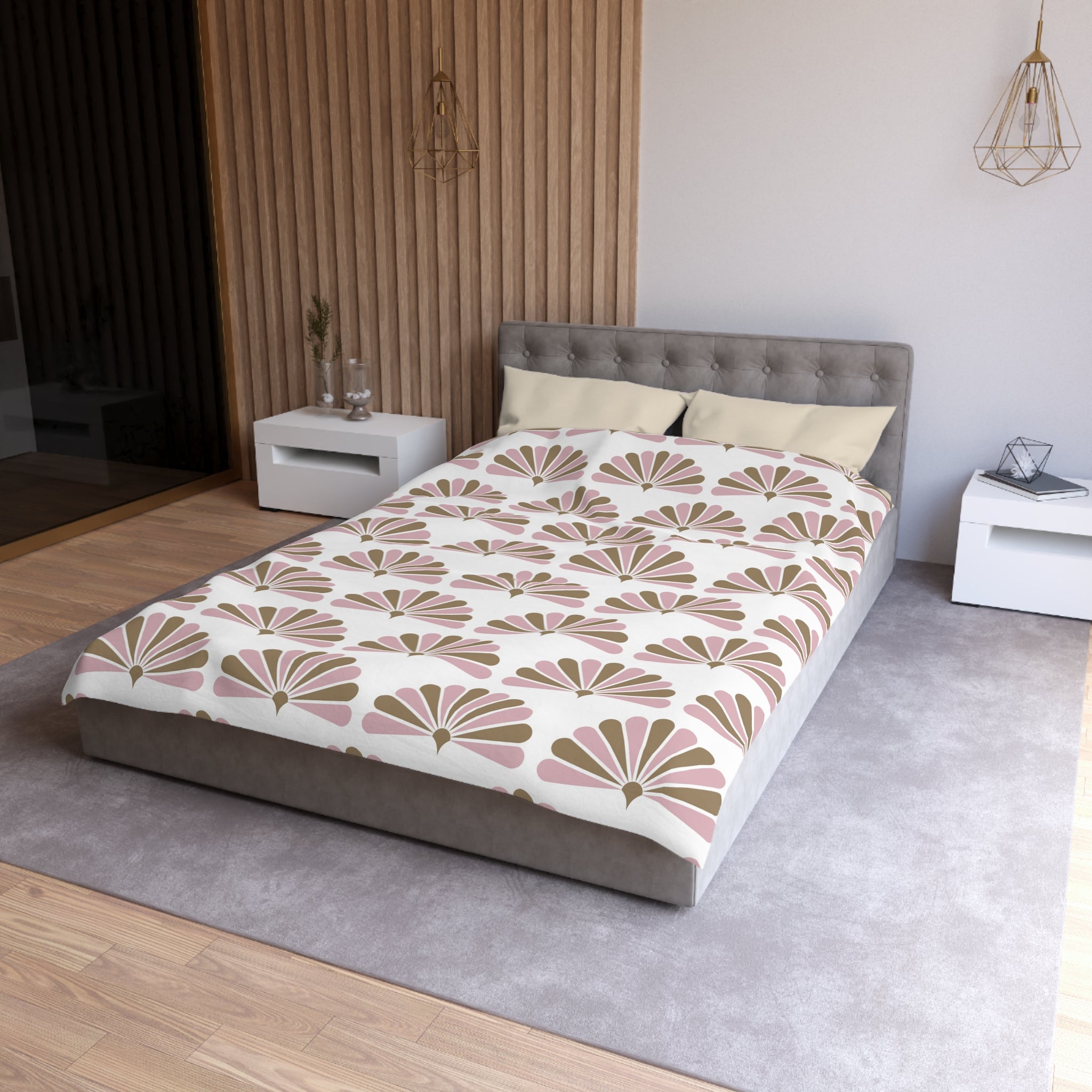 a modern bedroom with a gray tufted headboard, a white bedside table, and a gray area rug. The bed is covered in a comforter with a floral pattern in shades of pink and brown.