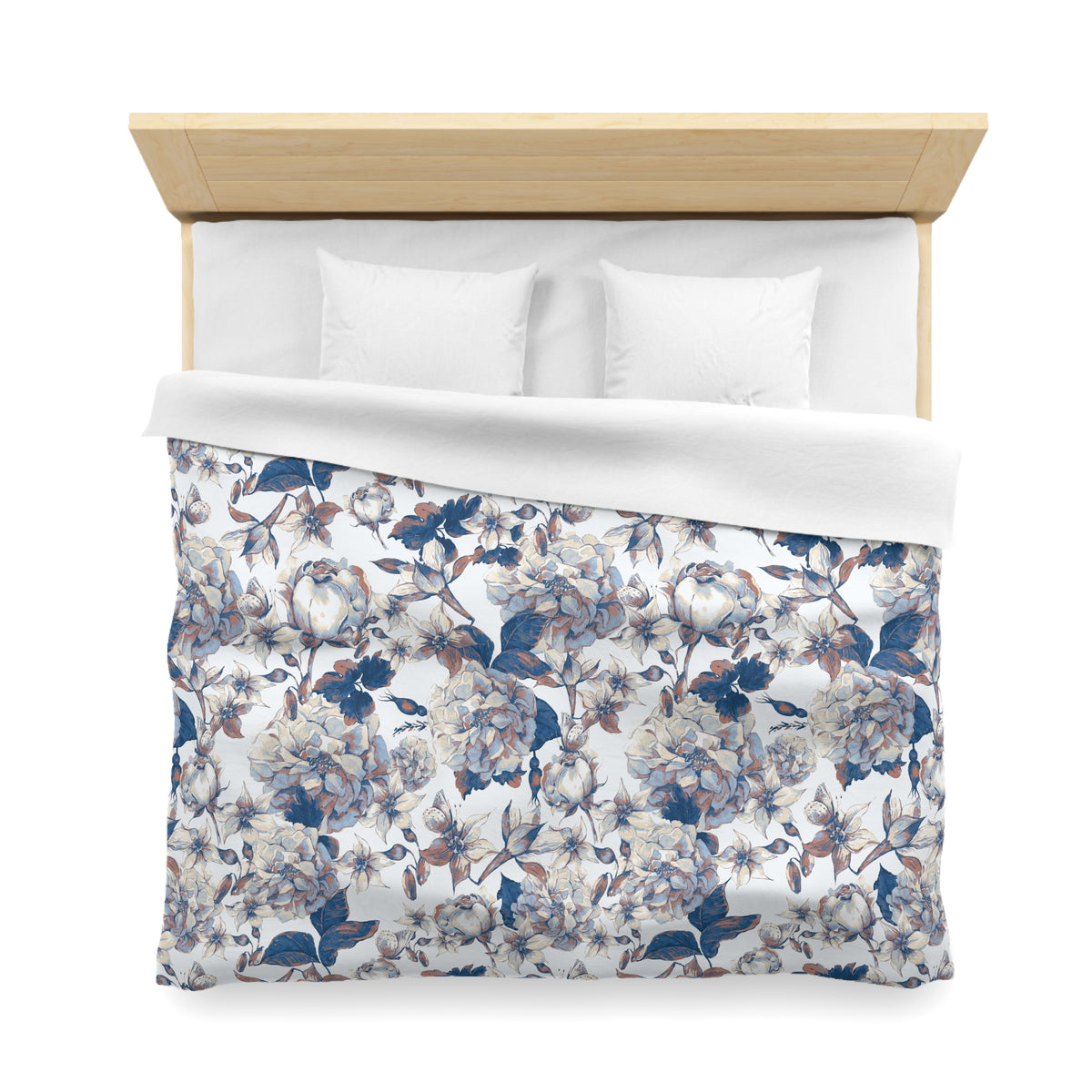 a neatly made bed with a floral patterned comforter and pillows.