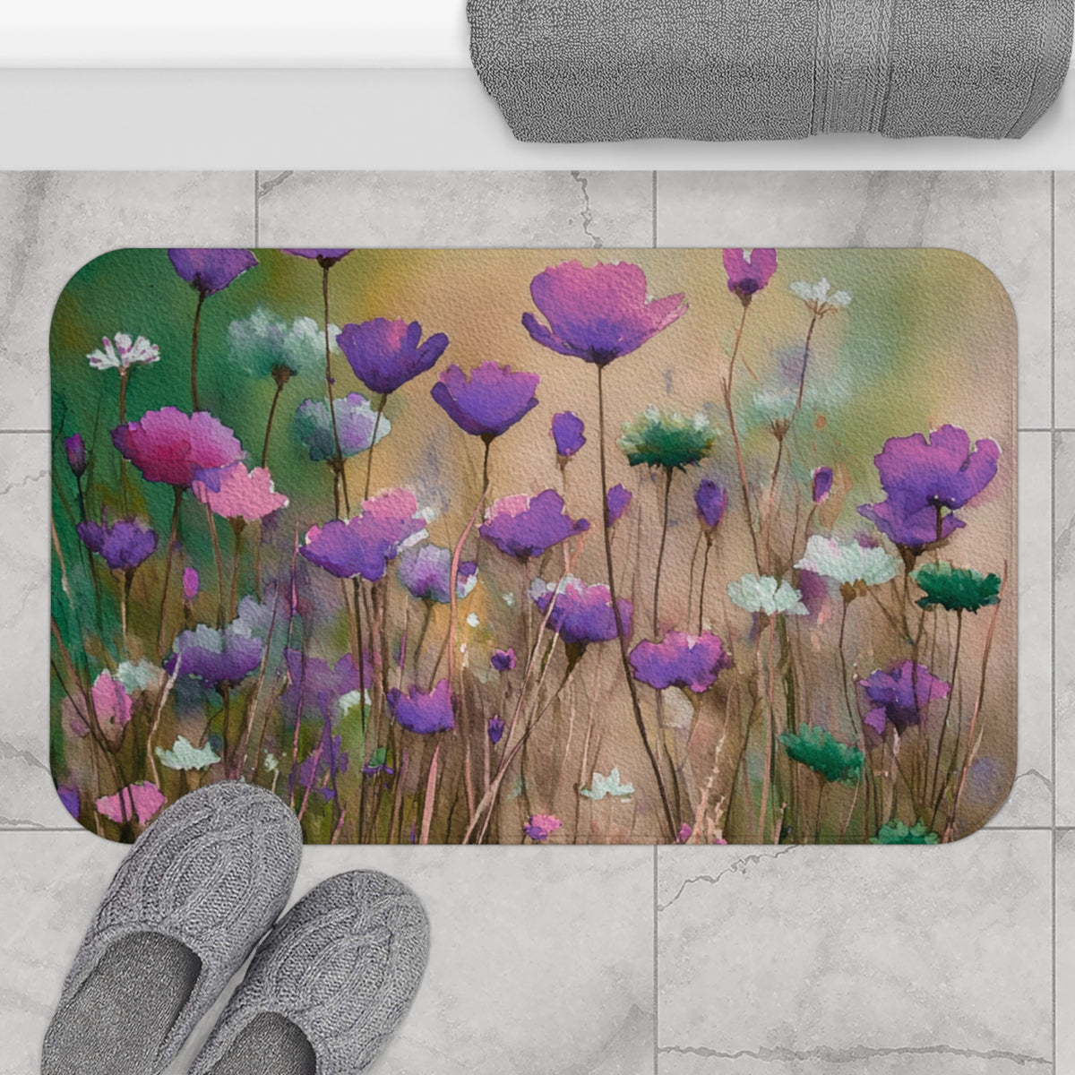 a bathroom floor with a decorative mat featuring a field of purple flowers. There are also gray slippers placed on the floor next to the mat.