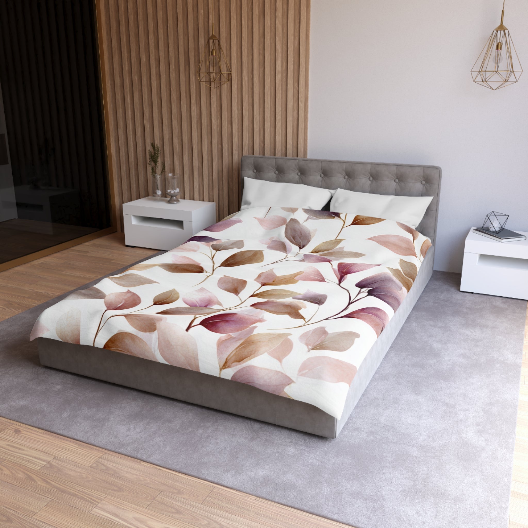 a modern bedroom with a large bed, a gray headboard, and a white nightstand on the left side. The bed is covered in a comforter with a leaf pattern, and there are two white pillows on the bed. The room has a neutral color scheme with a gray carpet and a wooden wall.