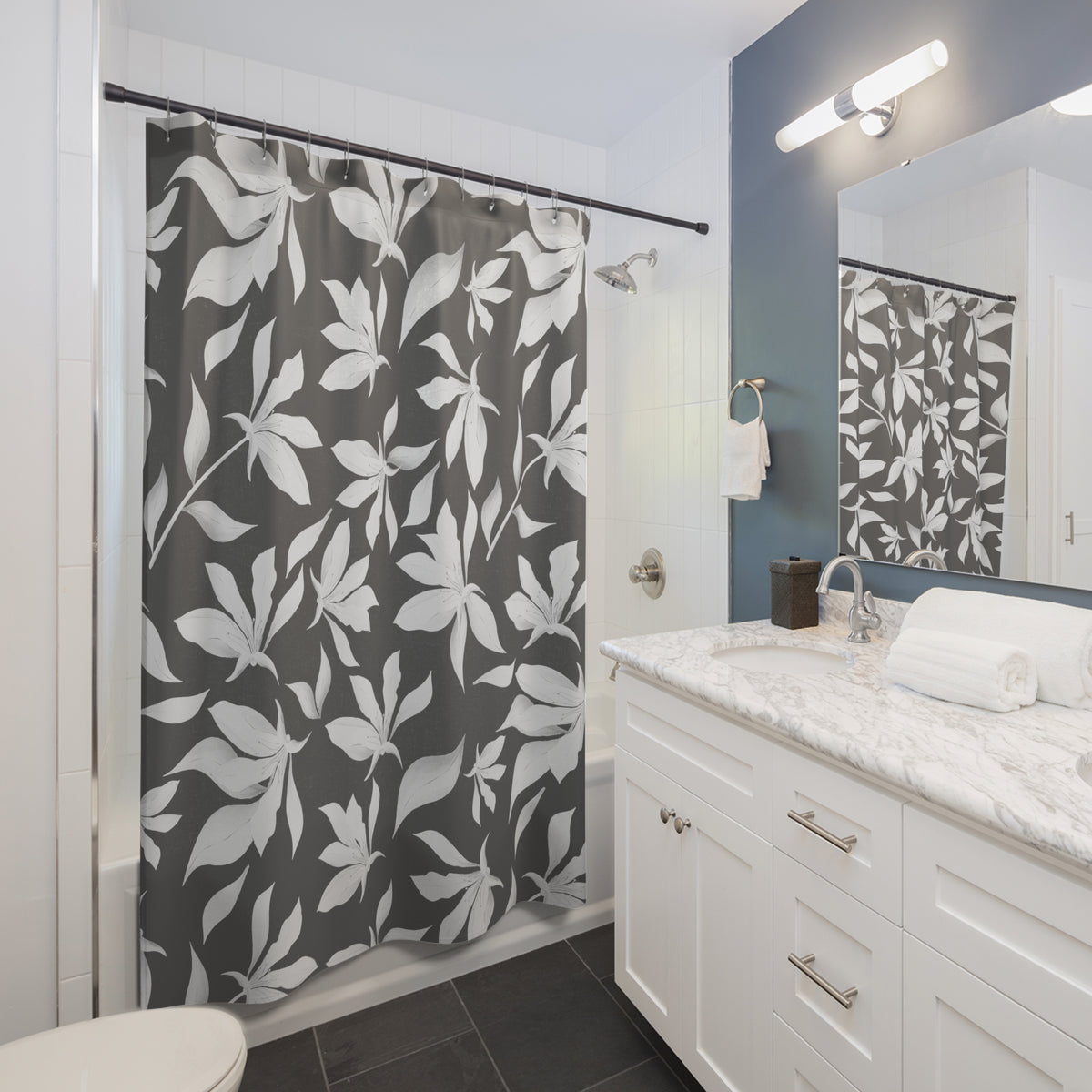 a modern bathroom with a white vanity, gray and white floral shower curtain, and a white sink with a marble countertop.