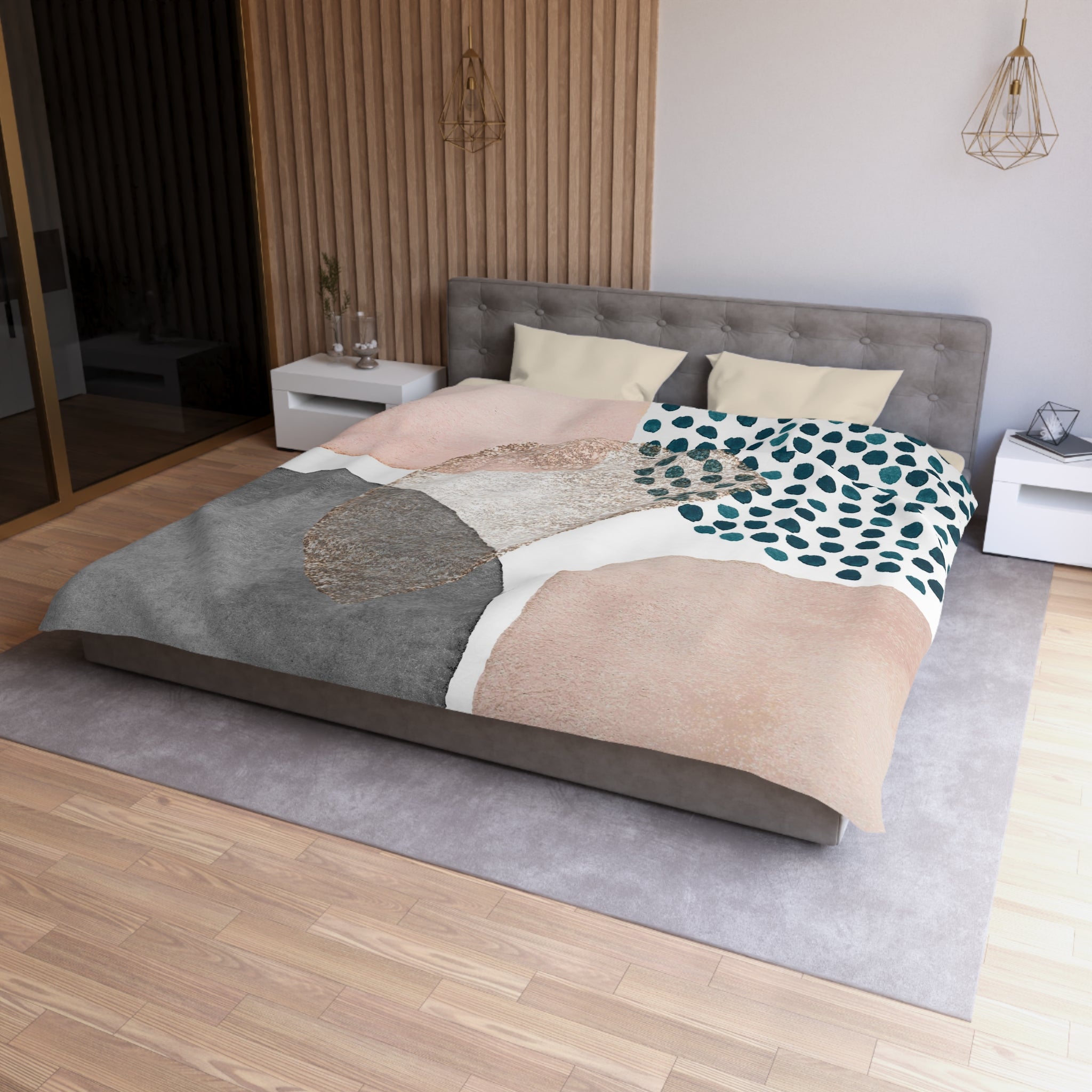 a modern bedroom with a large bed, a gray headboard, and a patterned comforter. The room has a wooden floor and white walls, creating a clean and minimalist aesthetic.
