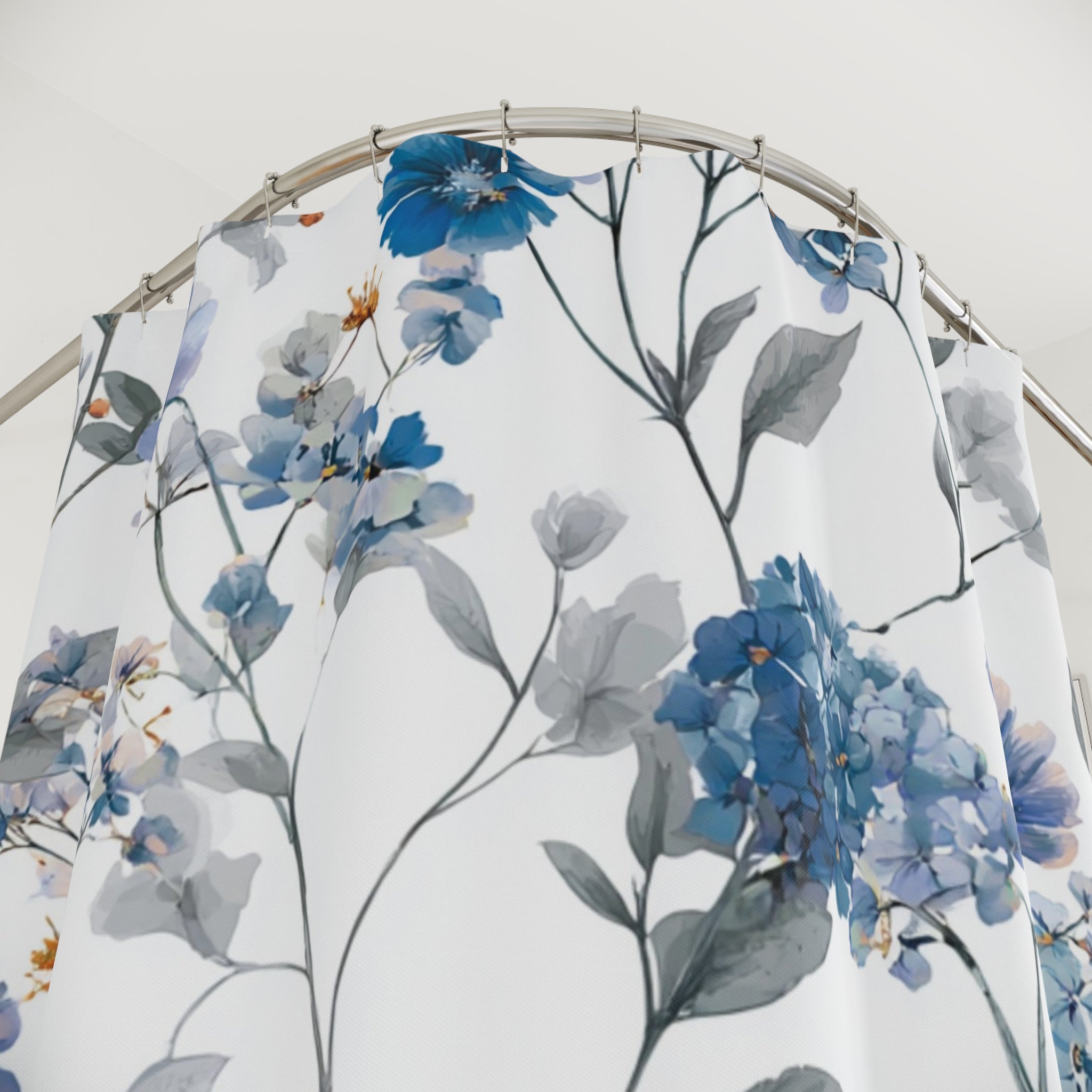 a shower curtain with a floral pattern of blue and white flowers and leaves.