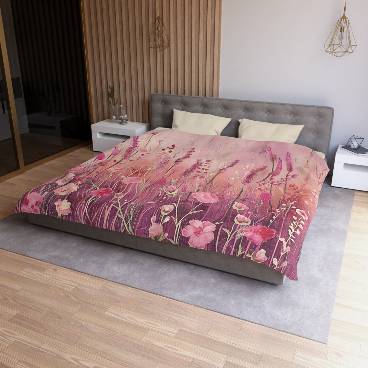 a bedroom with a large bed covered in a floral print comforter. The bed is positioned against a wall with a wooden panel. The room has a modern and minimalist design, with a gray headboard and white nightstands.