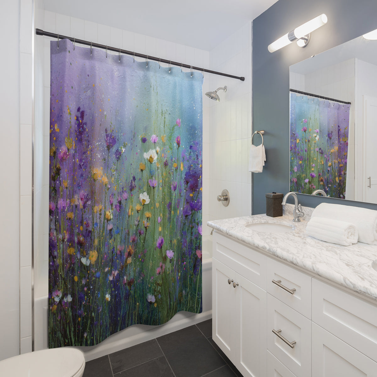 A bathroom with a shower curtain featuring a colorful floral pattern. The shower curtain is hanging in the shower area, and the bathroom has a white vanity and marble countertop.