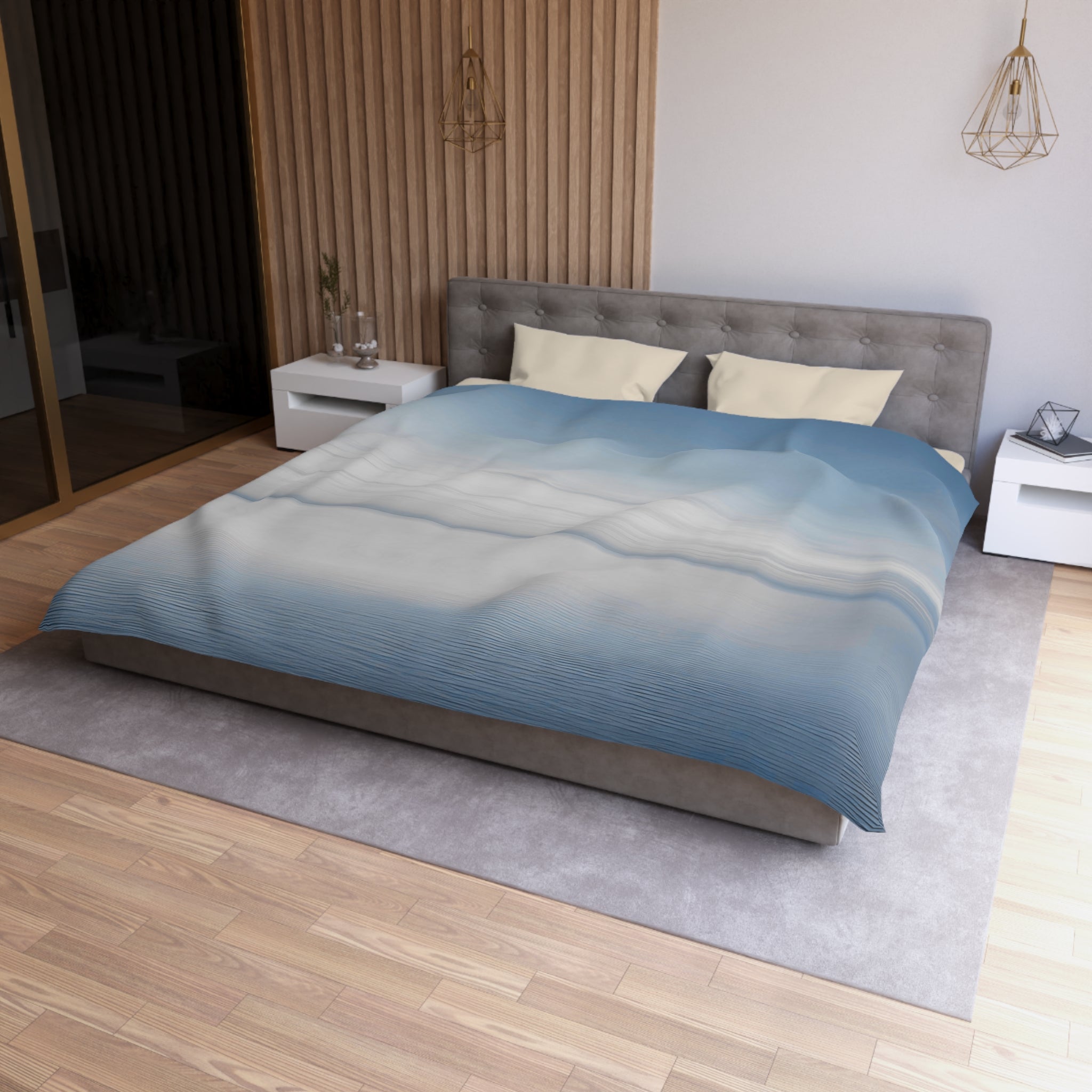 a modern bedroom with a large bed, a gray headboard, and a blue and white patterned comforter. The room has a wooden floor and white walls, creating a clean and minimalist aesthetic.