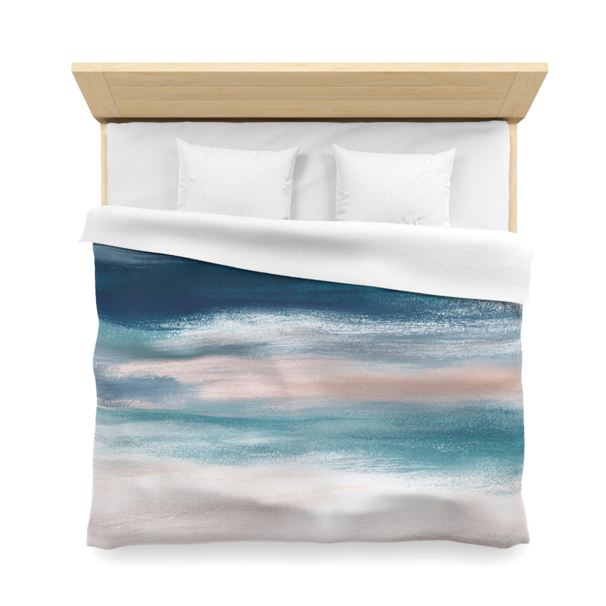 a neatly made bed with a white comforter and pillows. The comforter has a colorful abstract painting of a beach scene, featuring shades of blue, pink, and white.