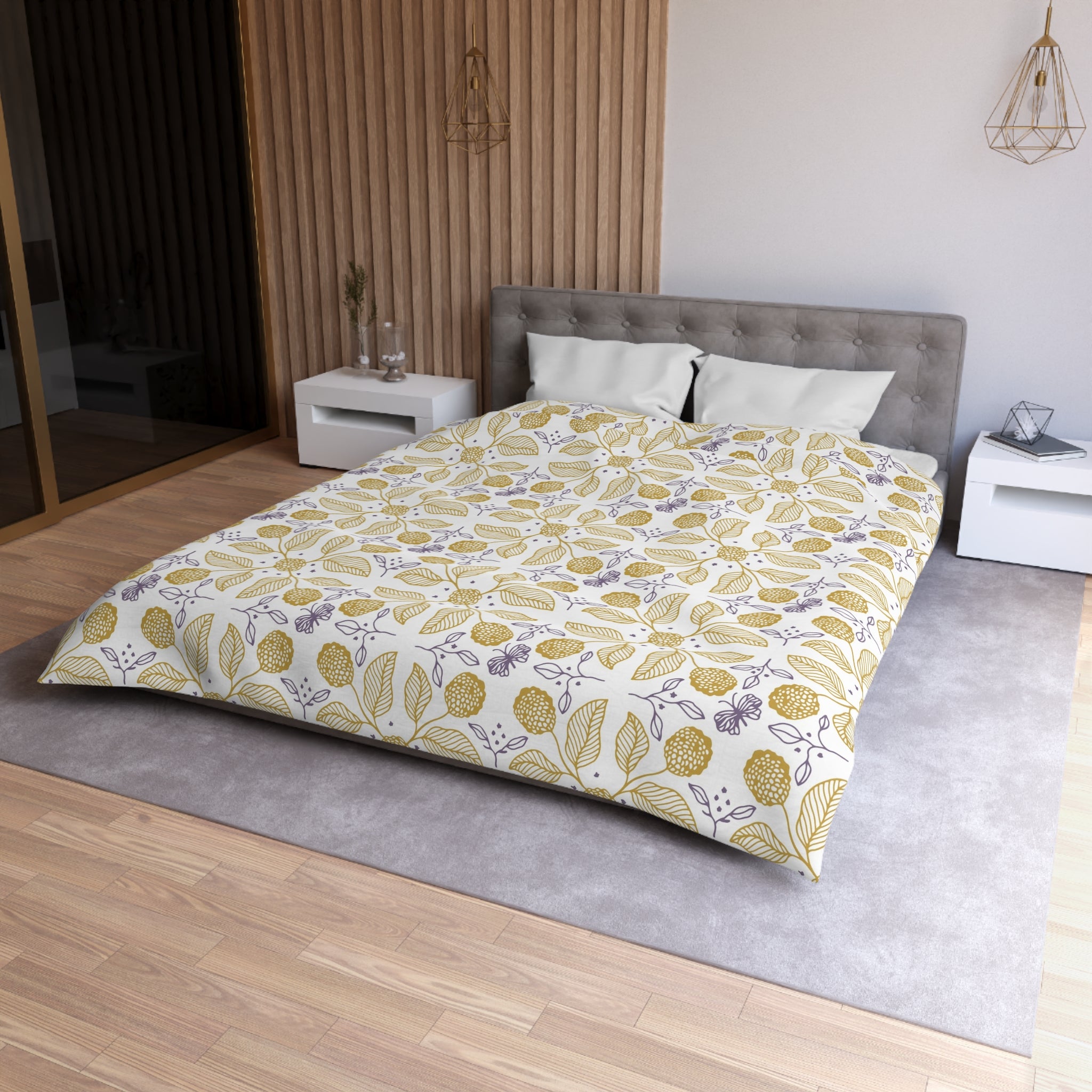 A modern bedroom with a large bed, white nightstands, and a wooden headboard. The bed has a yellow and white floral comforter and a gray headboard. The room has a neutral color scheme with wooden paneling on the walls and a gray carpet.