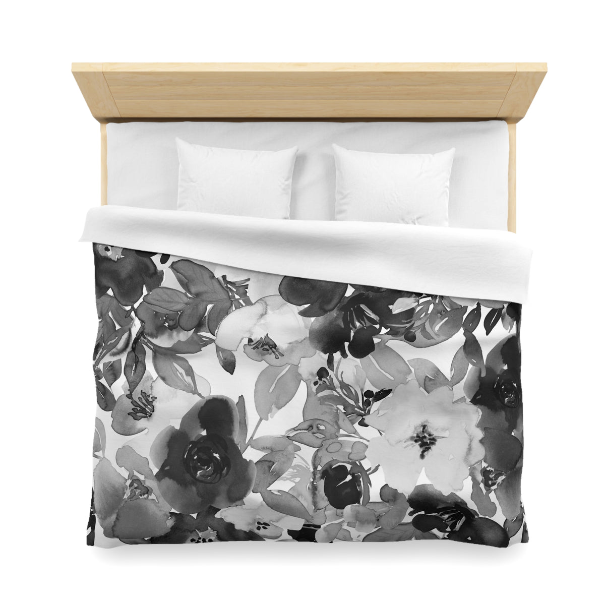a neatly made bed with a floral print duvet cover and two white pillows.