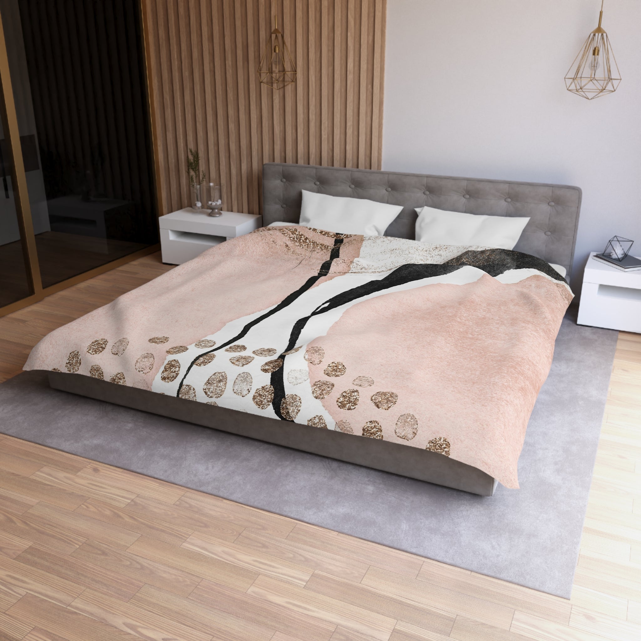 a modern bedroom with a large bed, a gray headboard, and a wooden floor. The bed is covered with a pink and black patterned comforter, and there are two white pillows on the bed. The room also features a nightstand, a pendant light, and a mirror.