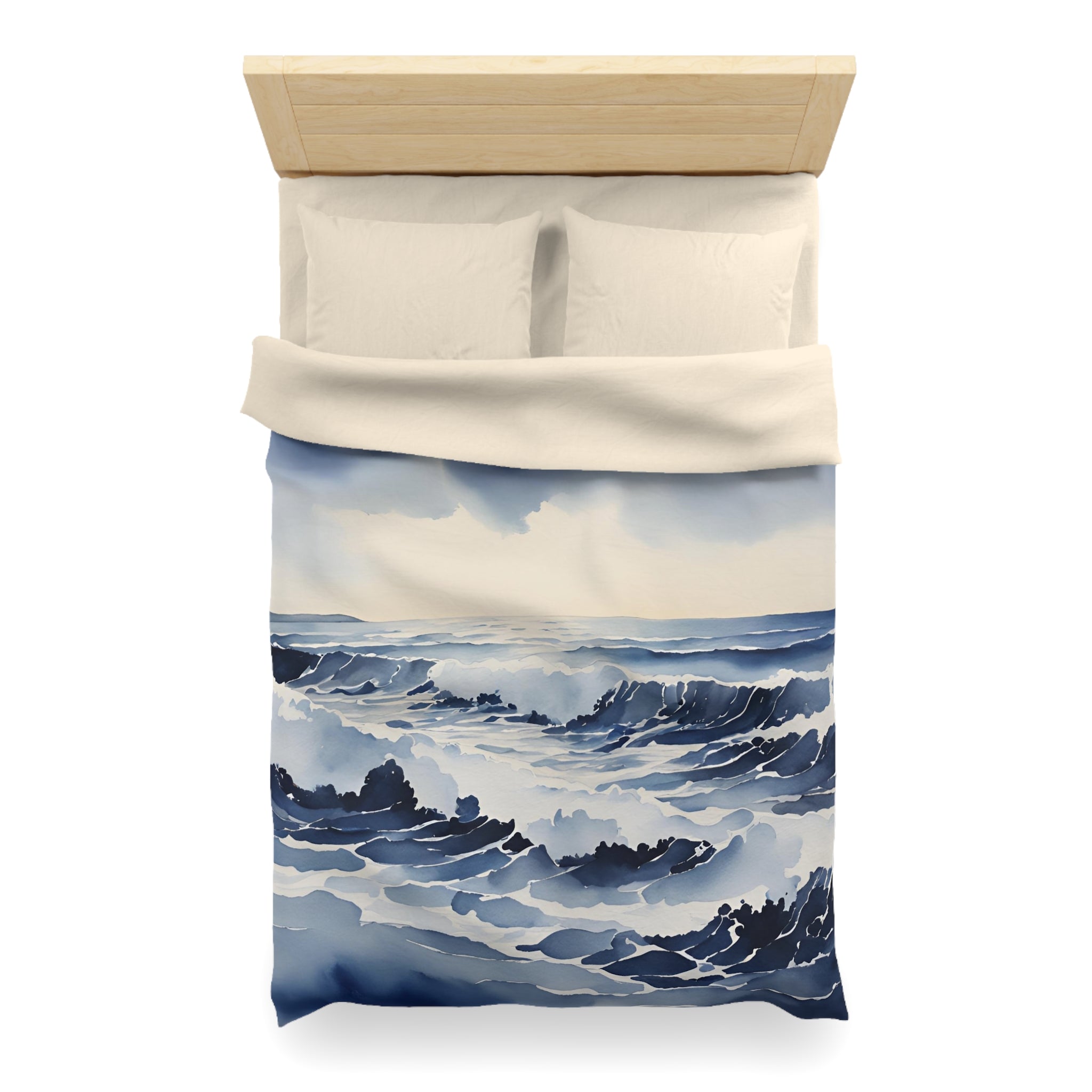 a bed with a blue and white ocean-themed duvet cover featuring a painting of waves crashing on the shore.