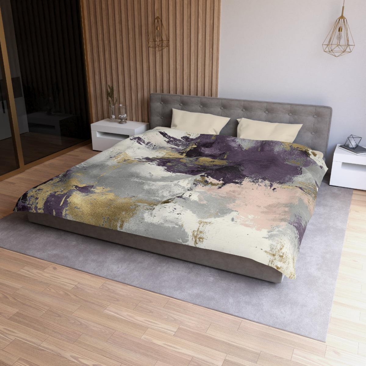 a modern bedroom with a large bed, a gray headboard, and a colorful abstract patterned comforter. The room has a wooden floor and white walls, creating a clean and minimalist aesthetic.