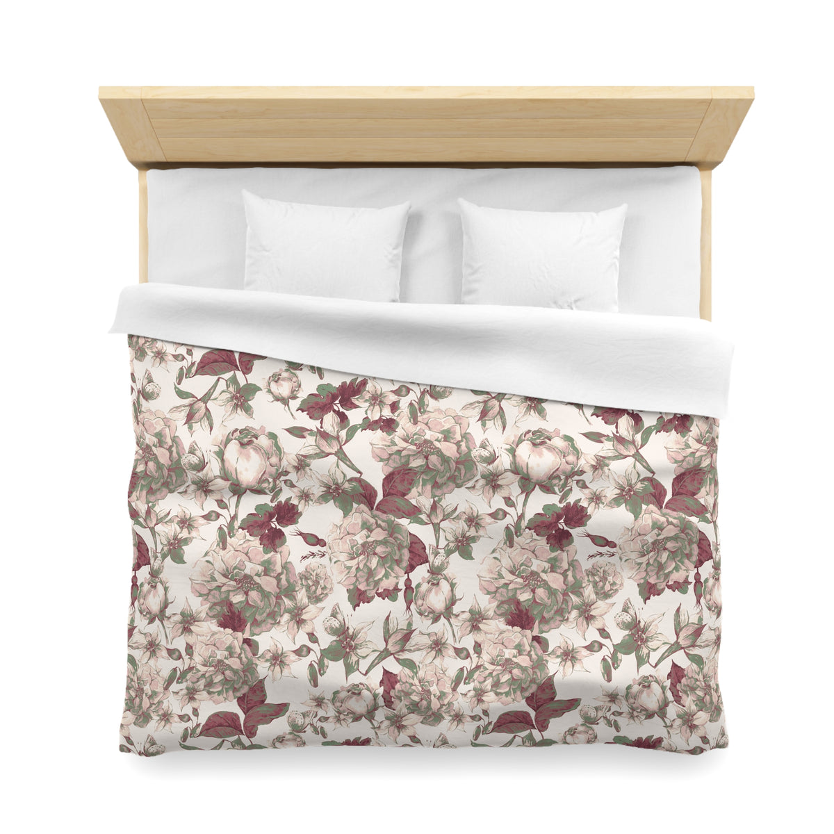 a neatly made bed with a floral print comforter and two white pillows.