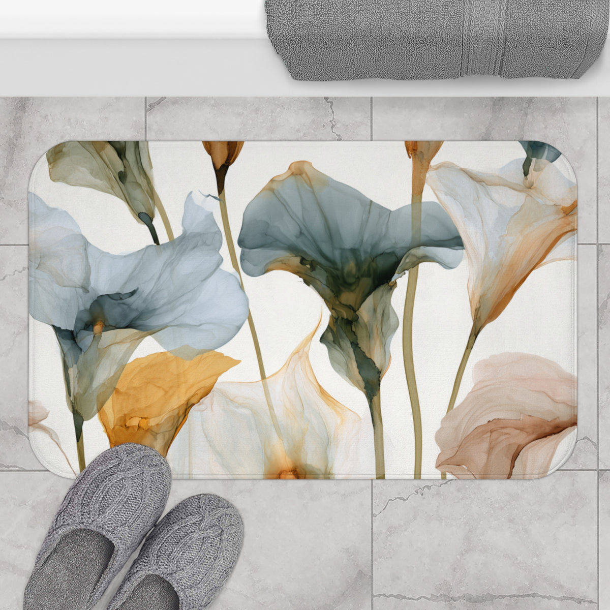 a bathroom mat with a floral design, including various shades of blue, green, and orange flowers. The mat is placed on a tiled floor, and there are gray slippers positioned next to it.