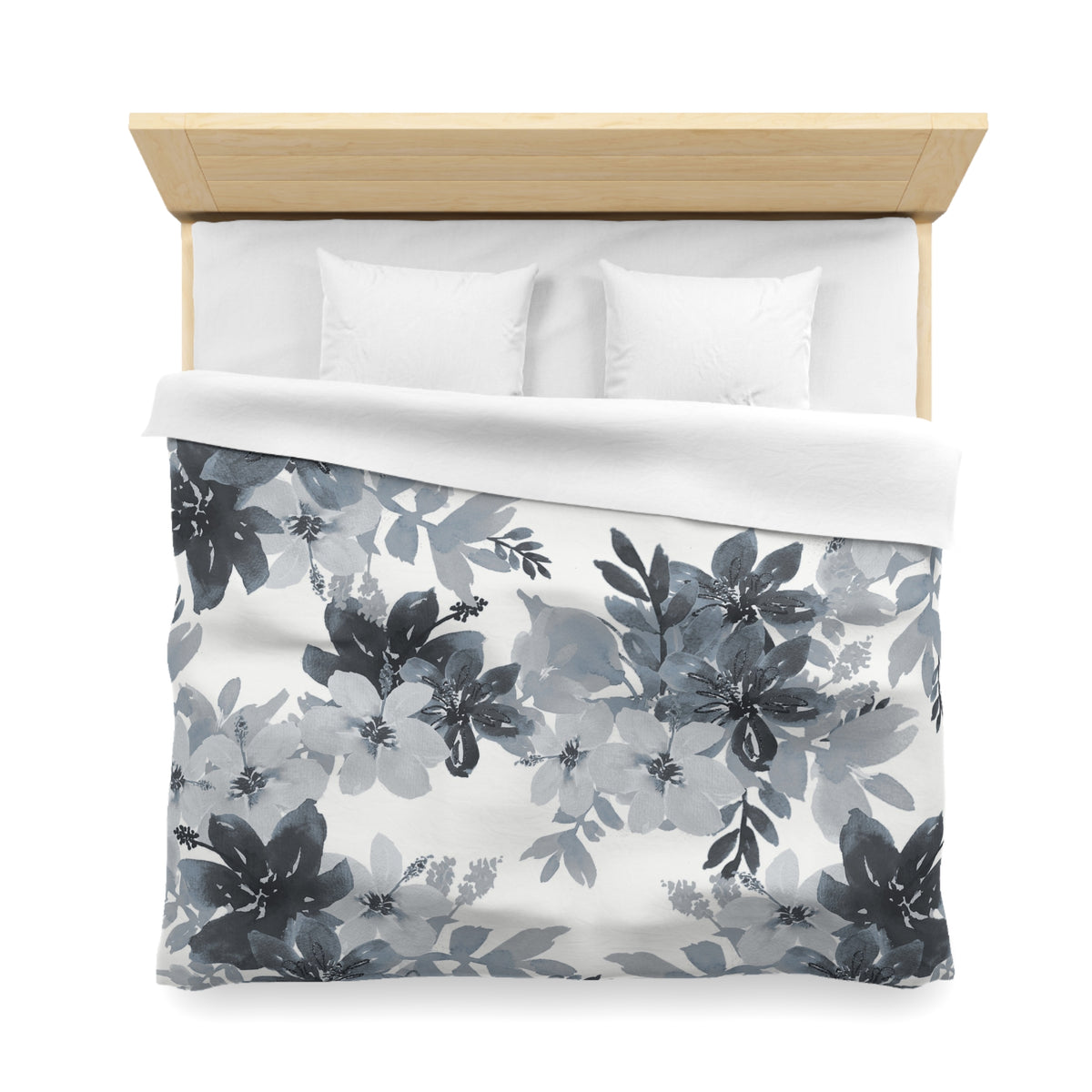 a neatly made bed with a floral print duvet cover and two white pillows.