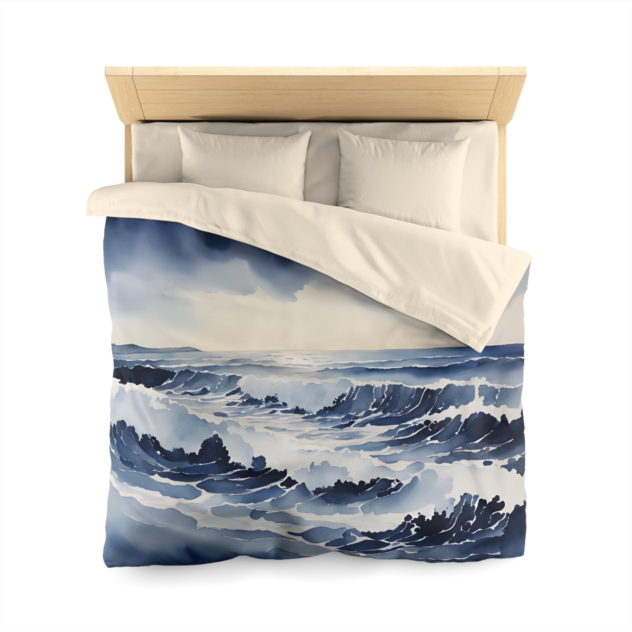 a bed with a blue and white ocean-themed duvet cover featuring a painting of crashing waves.