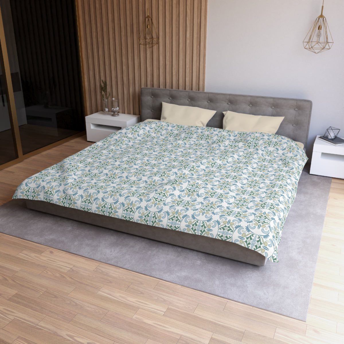 a modern bedroom with a large bed, a gray headboard, and a patterned comforter. The room has a wooden floor and white walls, creating a clean and minimalist aesthetic.