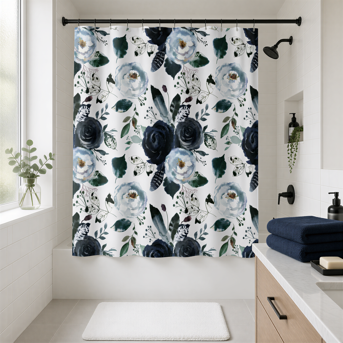 a bathroom with a floral print shower curtain hanging in the shower area. The shower curtain has a mix of blue and white flowers and leaves, creating a visually appealing pattern. The bathroom also includes a sink, a mirror, and some decorative elements such as a potted plant and a soap dispenser.