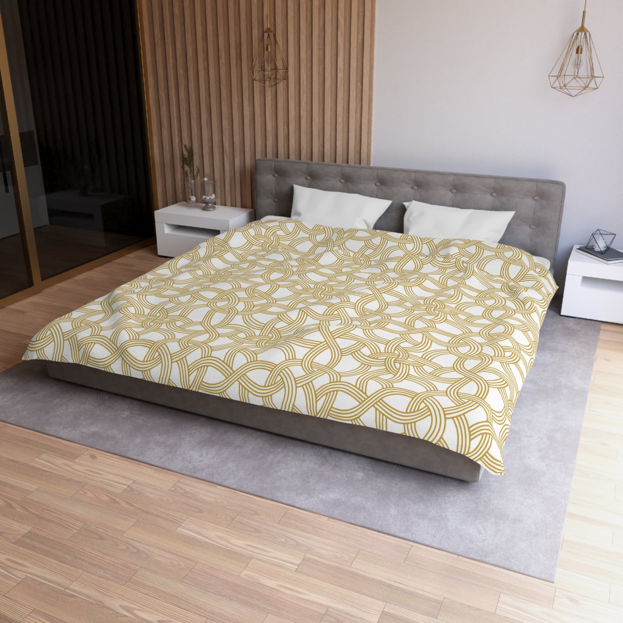 a modern bedroom with a large bed, a gray headboard, and a wooden floor. The bed is covered in a yellow and white patterned comforter, and there are two white pillows on the bed. The room also features a nightstand, a lamp, and a mirror.