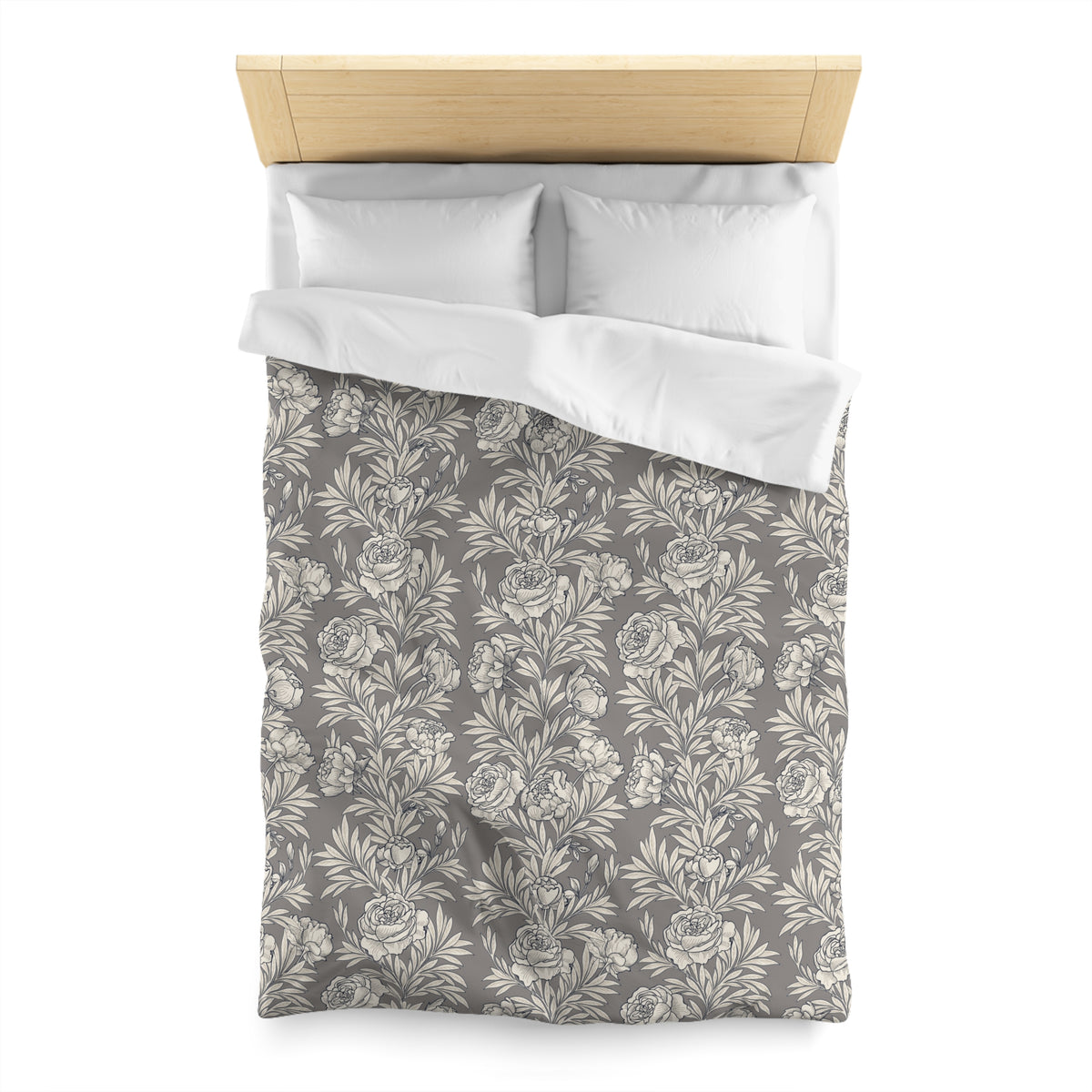 a neatly made bed with a gray and white floral patterned comforter and pillows.