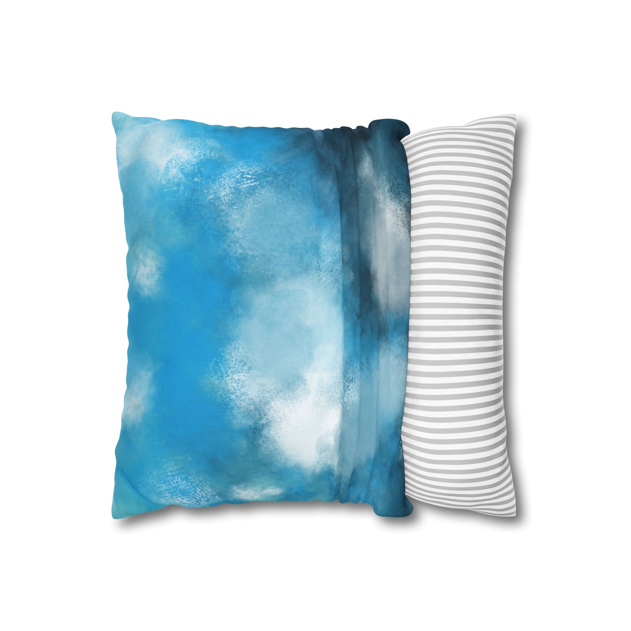 a square pillow with a blue and white color scheme, featuring a cloud-like pattern on the blue section and a striped pattern on the white section.