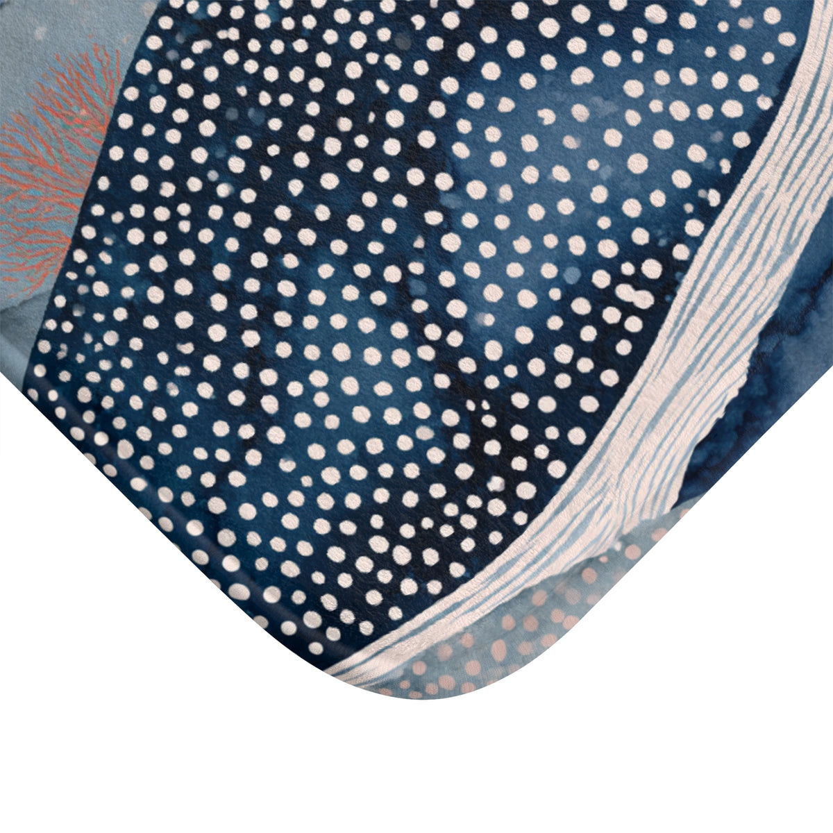 a close-up view of a patterned fabric with a blue and white color scheme, adorned with white polka dots. The fabric appears to be a bath mat or rug, with a textured and visually appealing design.