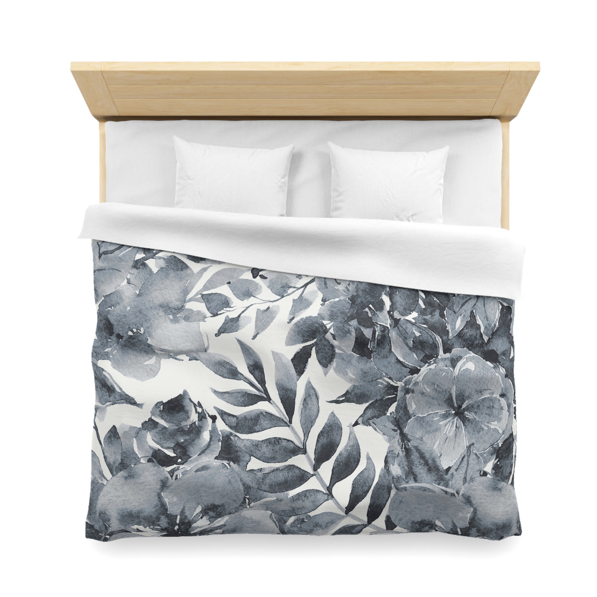 a neatly made bed with a gray and white floral patterned comforter and pillows.
