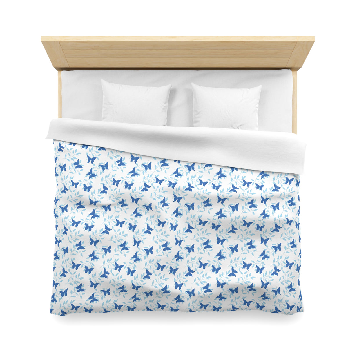 a neatly made bed with a blue and white patterned comforter and two white pillows.