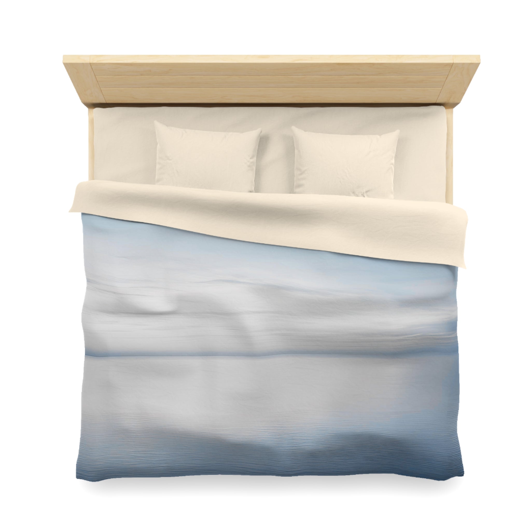 A neatly made bed with a blue and white patterned comforter and two white pillows.