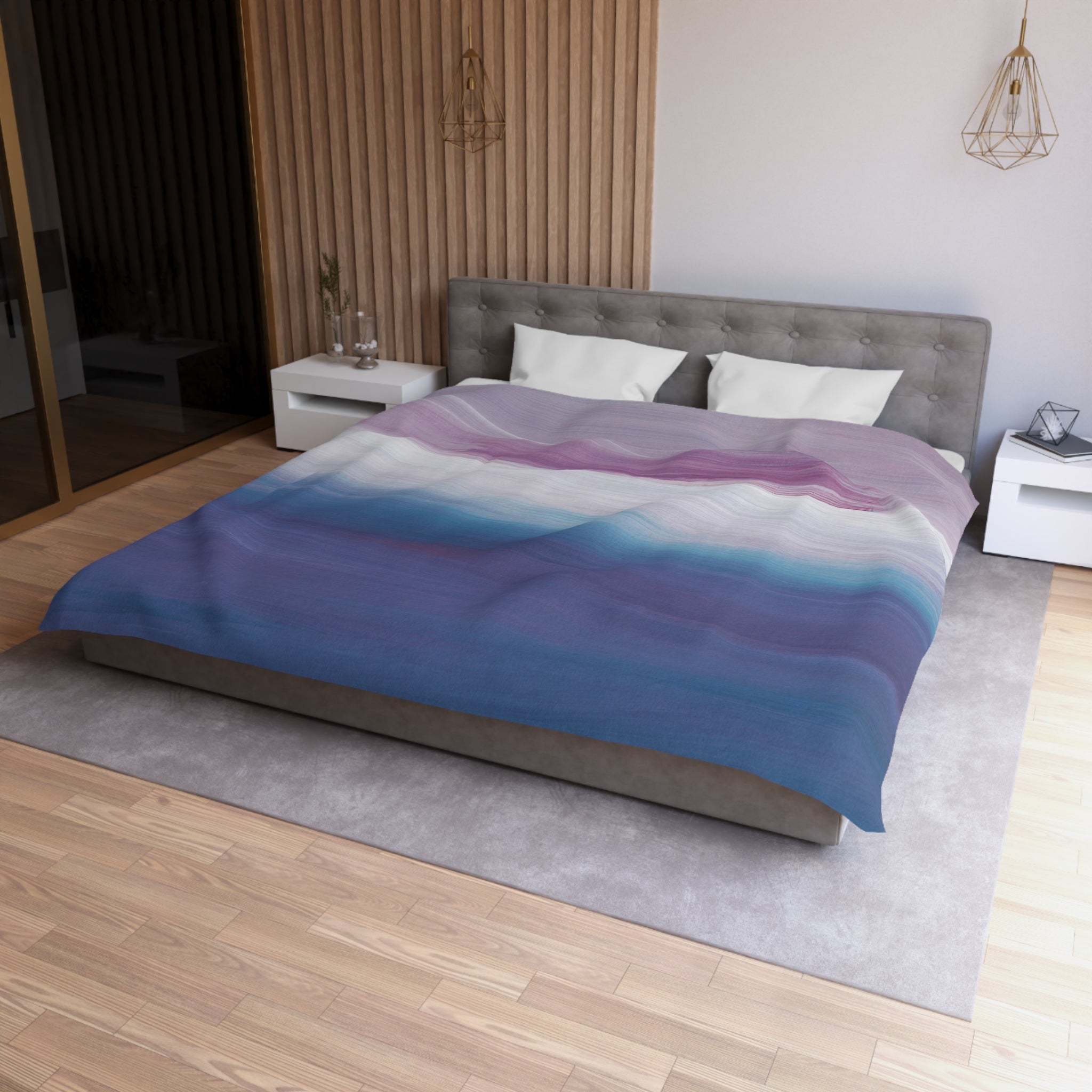 a modern bedroom with a large bed, a gray headboard, and a colorful striped comforter. The room has a wooden floor and white walls, creating a clean and minimalist aesthetic.