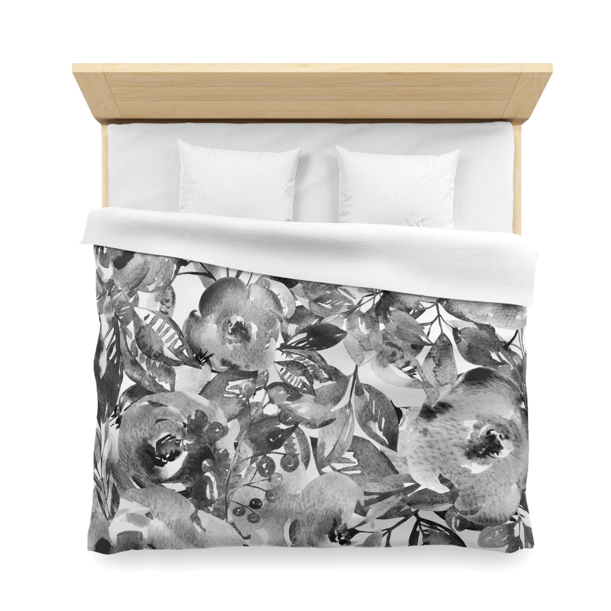 a bed with a black and white floral patterned comforter and pillows.
