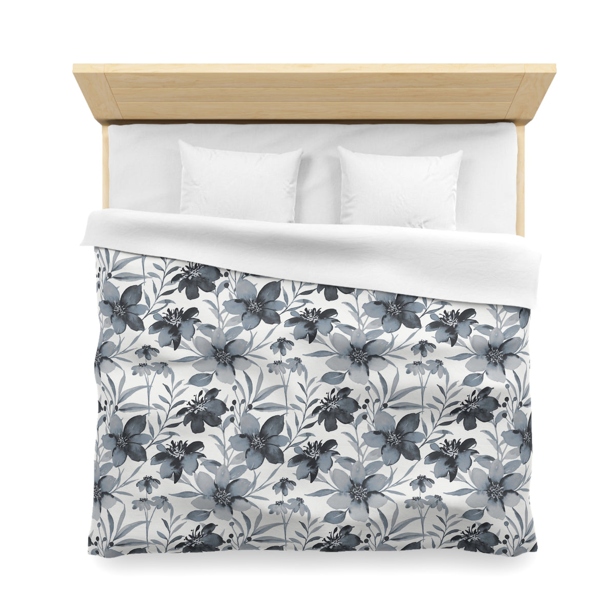 a neatly made bed with a floral patterned comforter and pillows.