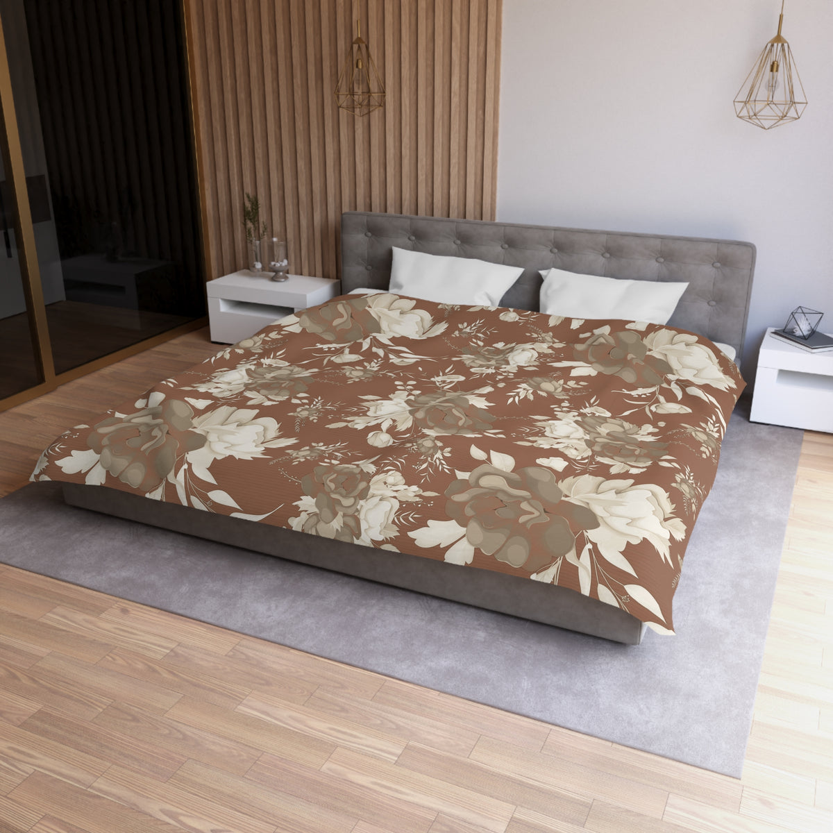 a modern bedroom with a large bed, a gray headboard, and a floral print bedspread. The room has a wooden floor and white walls, creating a warm and inviting atmosphere.