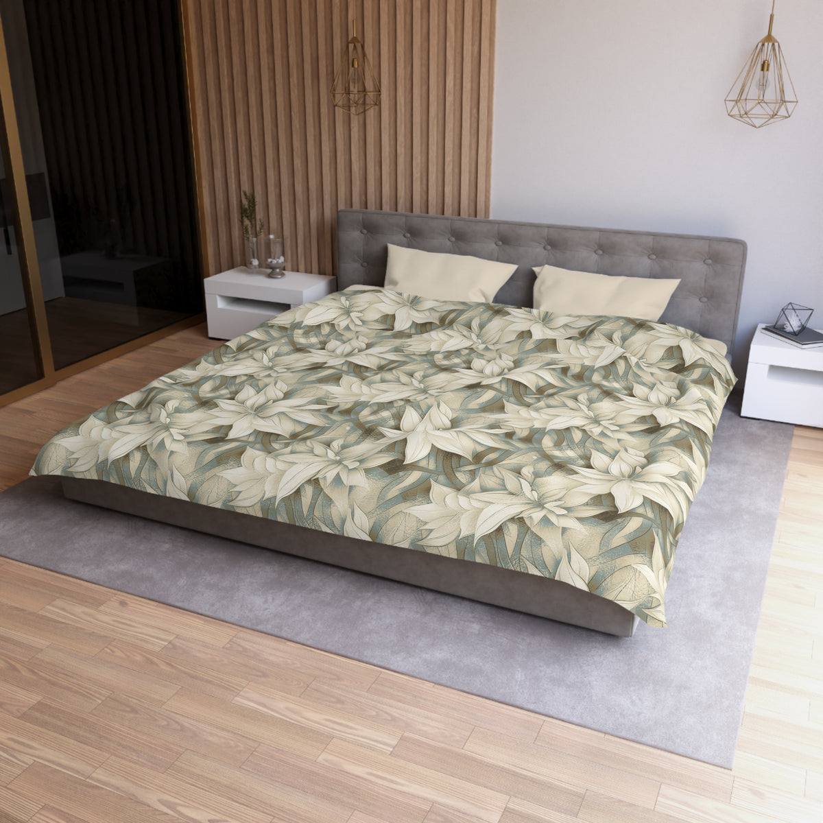 a modern bedroom with a large bed, a gray headboard, and a wooden floor. The bed is covered in a floral print comforter, and there are two pillows on it. The room has a minimalist and clean design, with a white nightstand and a pendant light hanging above the bed.