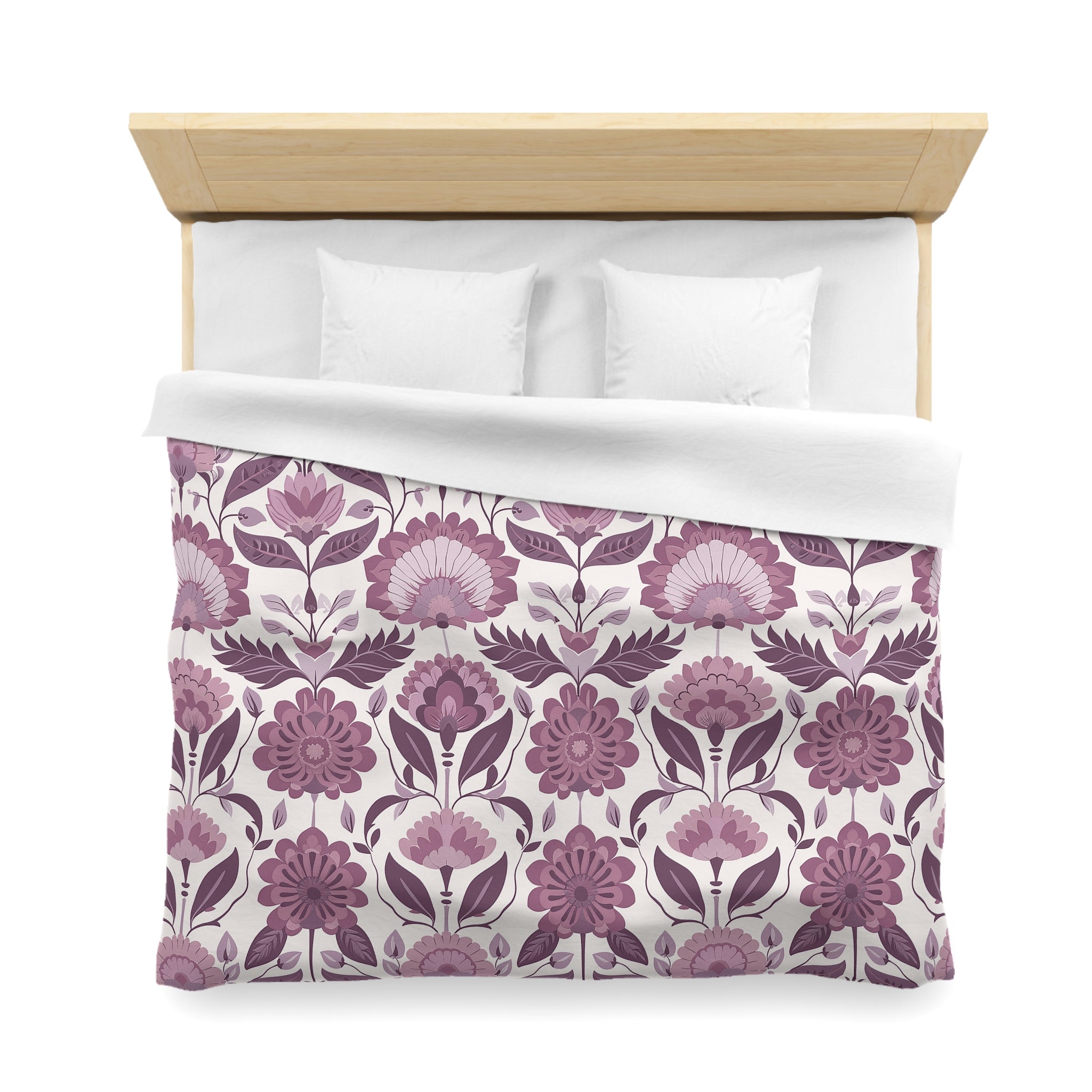 a neatly made bed with a floral patterned comforter and pillows.