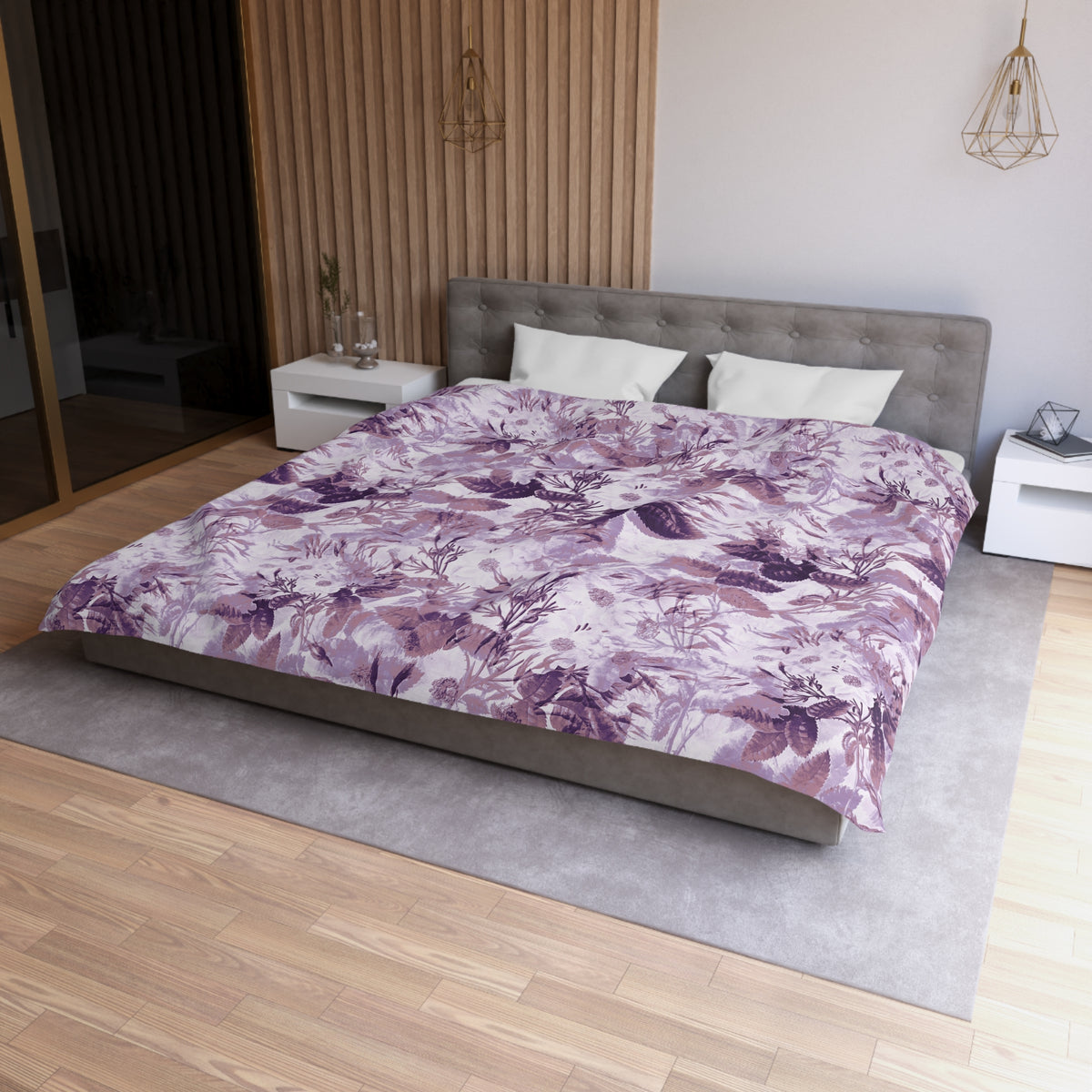 a modern bedroom with a large bed, a gray headboard, and a purple and white floral comforter. The room has a wooden floor and white walls, creating a serene and elegant atmosphere.