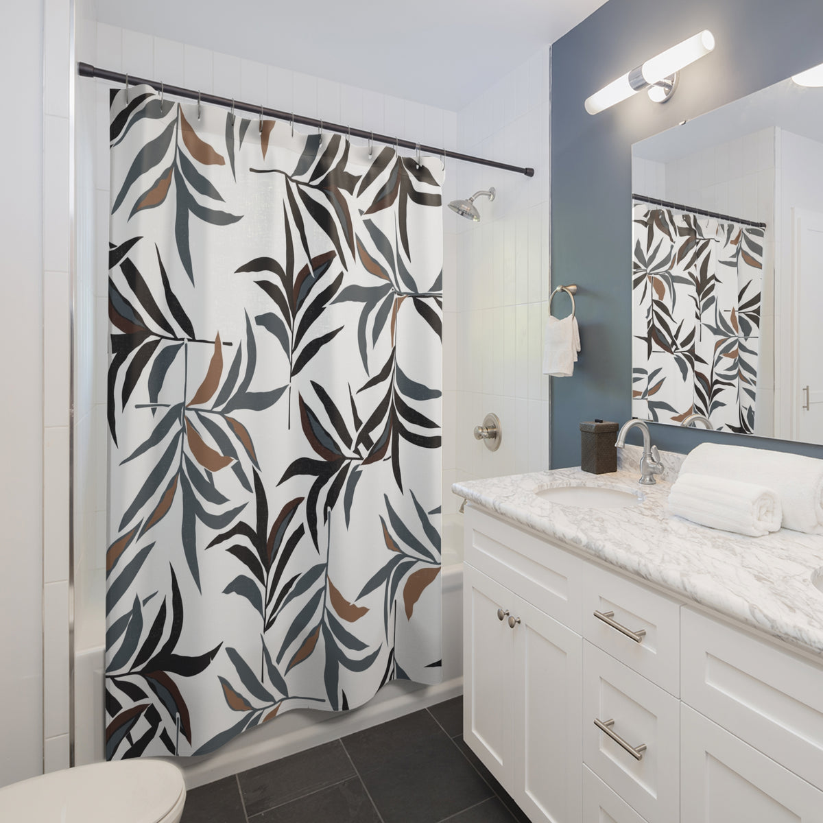 a modern bathroom with a white vanity, a shower curtain with a leaf pattern, and a mirror above the vanity.