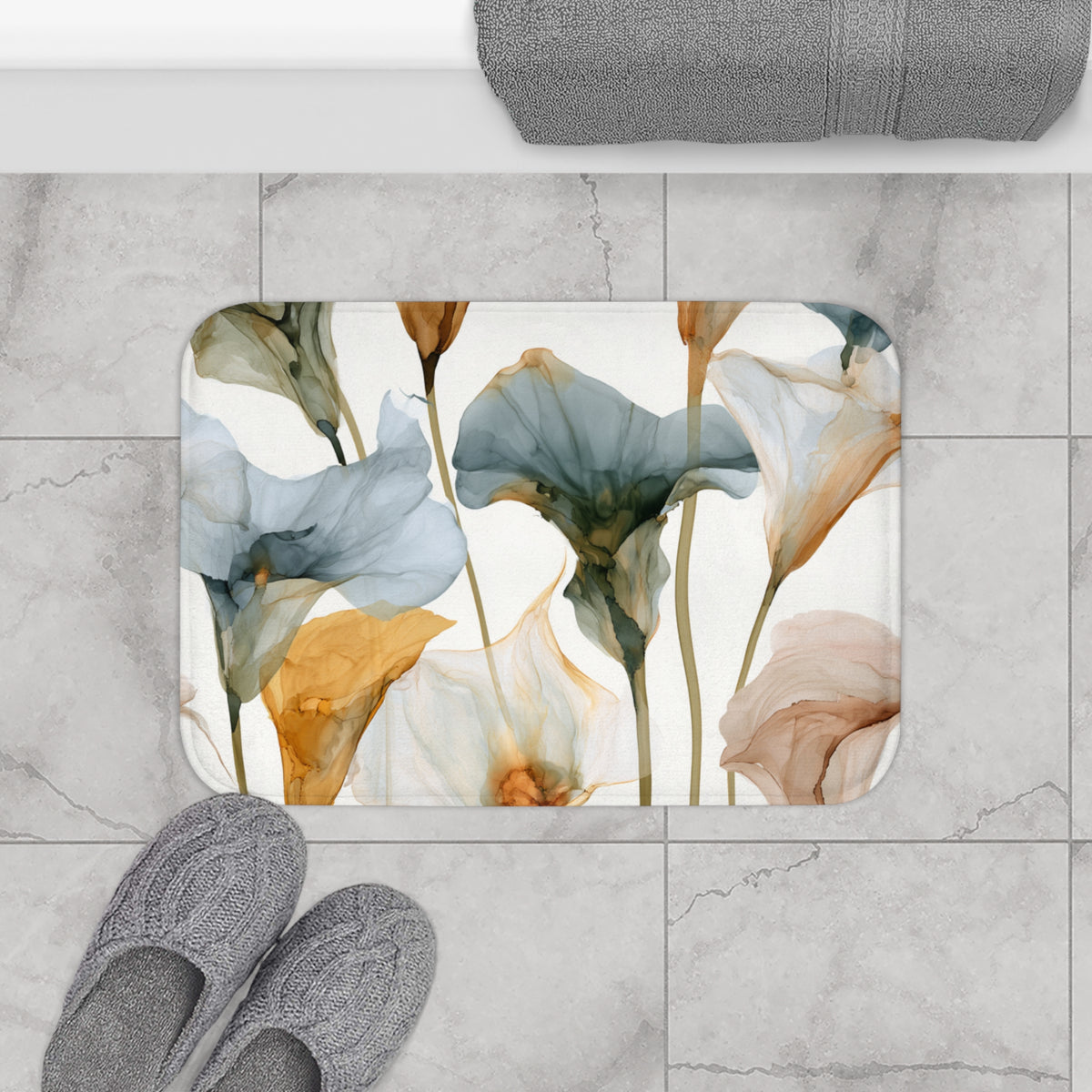 a bathroom floor with a decorative floral mat, gray slippers, and a towel.